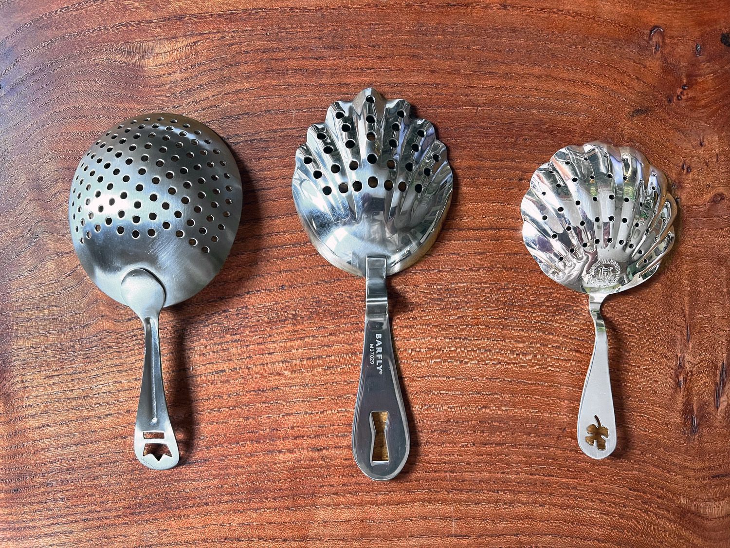 three strainers on a countertop with varying hole sizes.