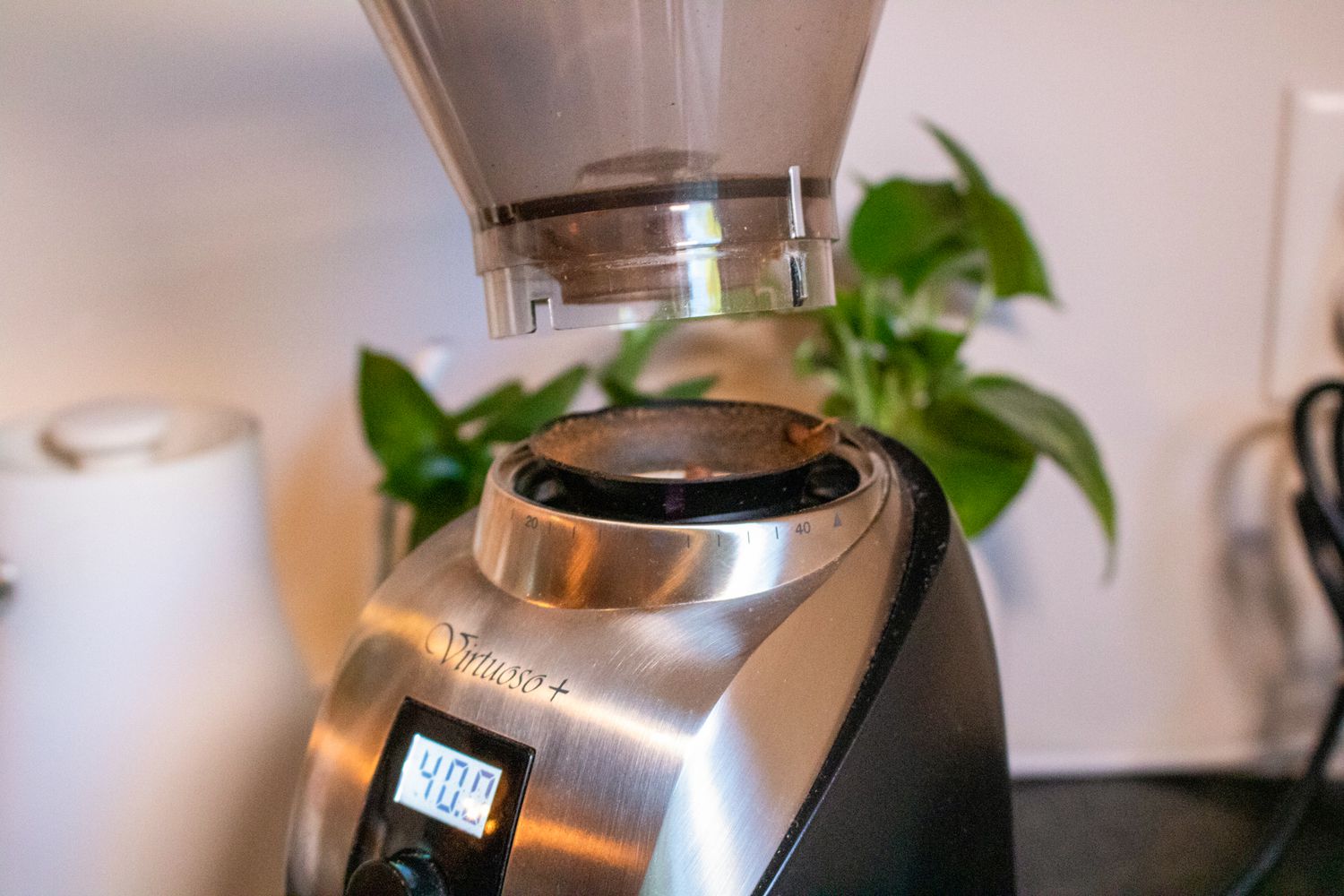 A bean hopper being removed from the base of a coffee grinder