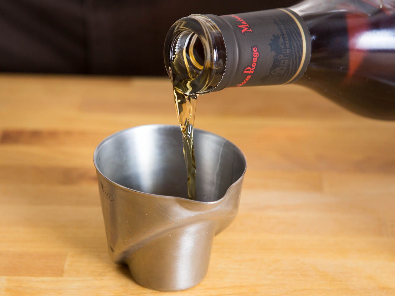 liquor being poured in a measuring cup