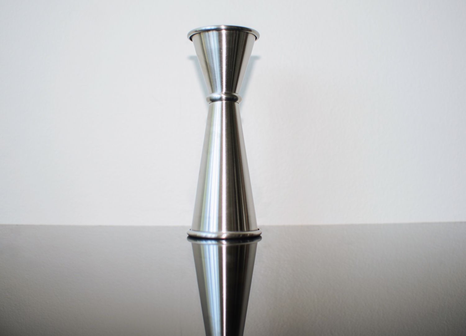 a conical, dual-sided style jigger on a black countertop