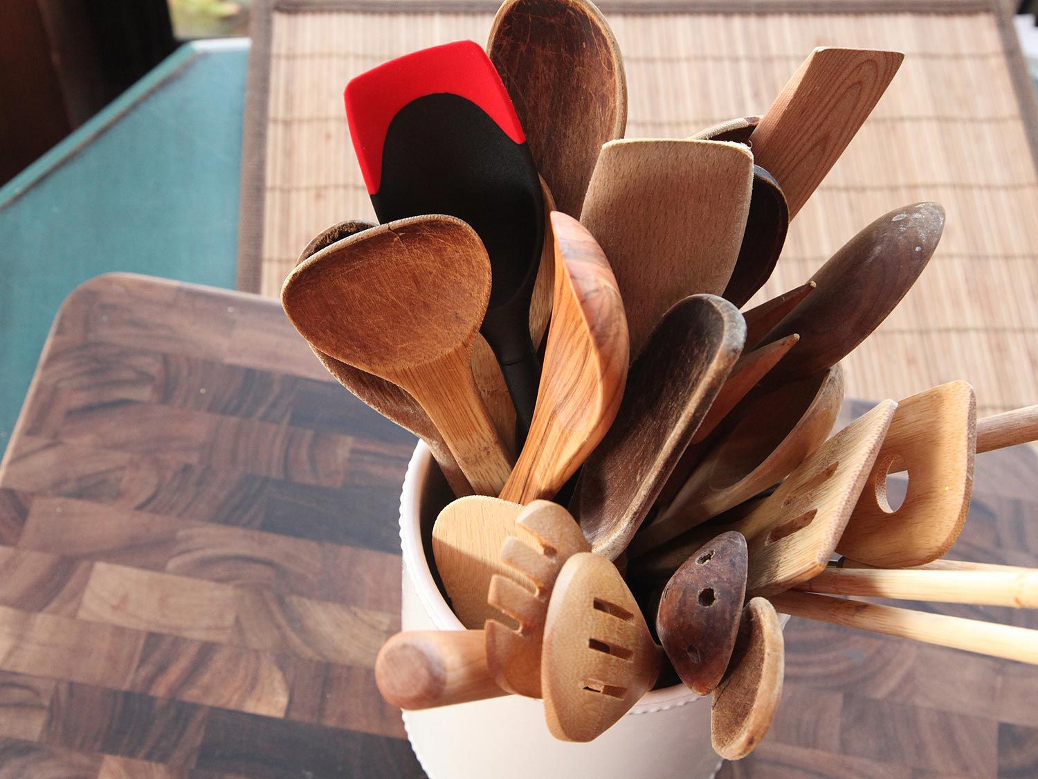 A utensil crock full of wooden and nylon spoons and spatulas