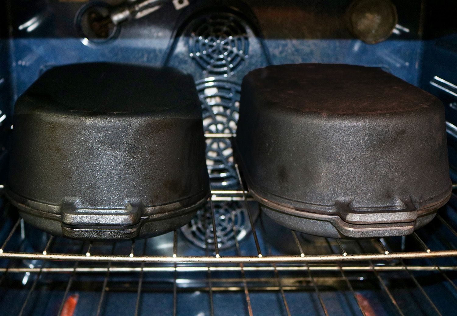two cast iron roasting pans sit in an oven side by side