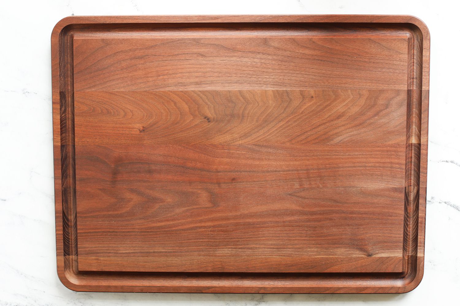 a wooden carving board on a marble surface