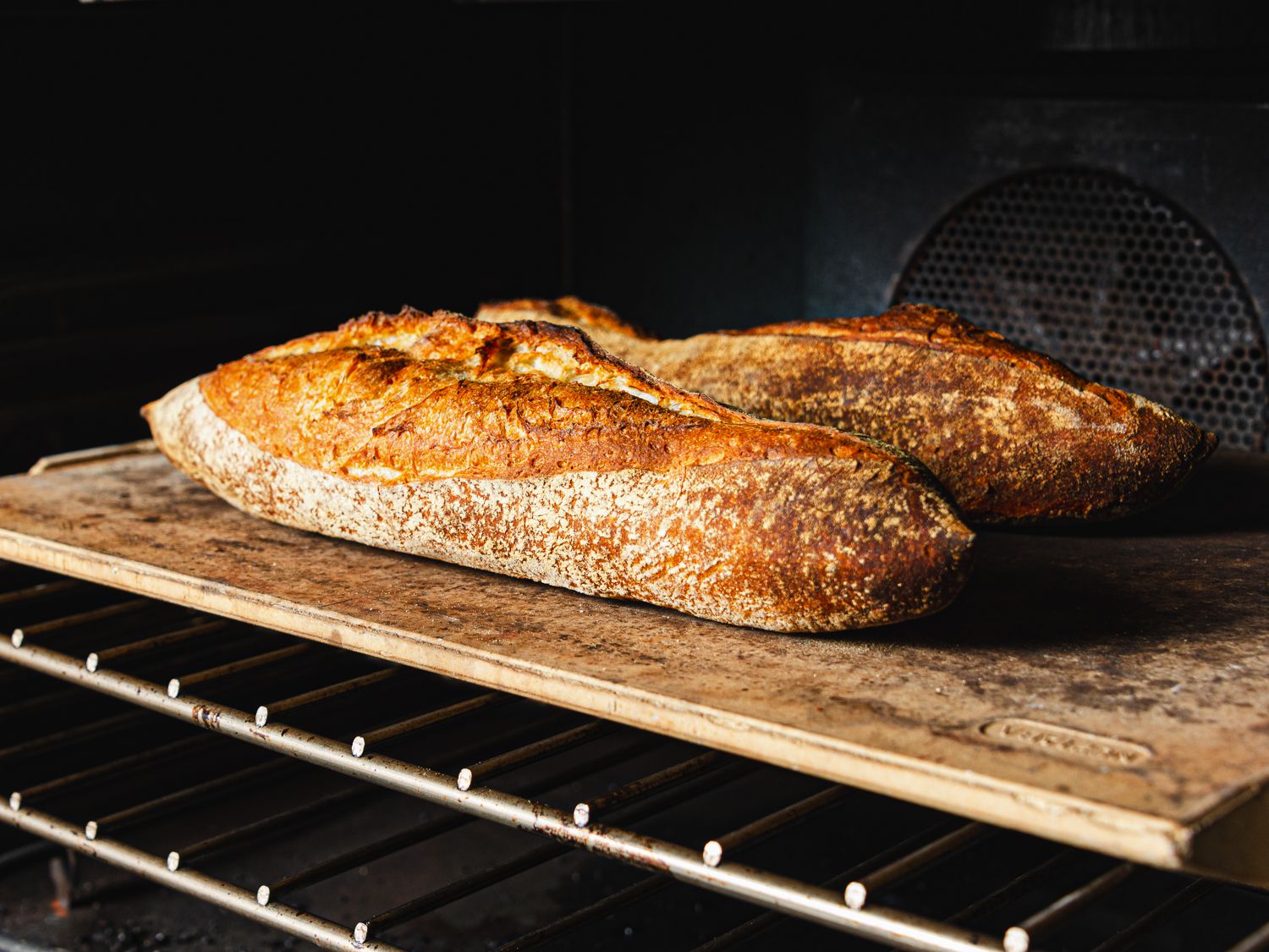 Loaves on a baking stone in an oven