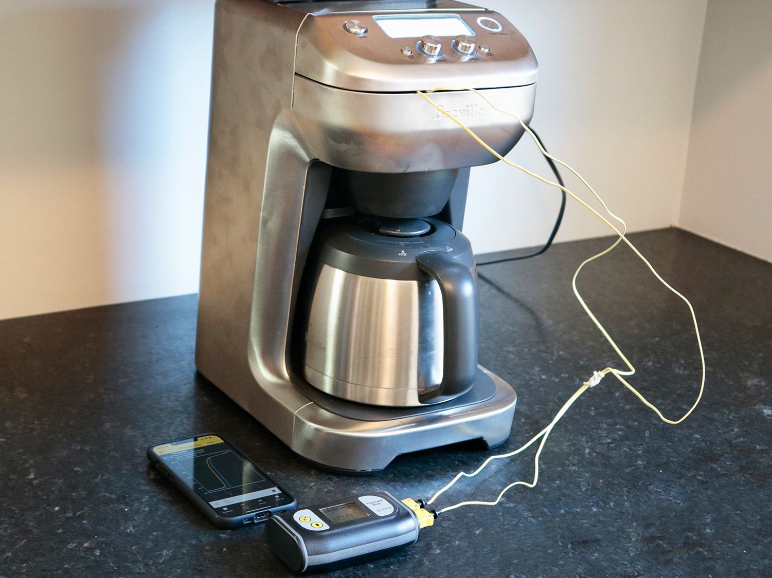 a coffee brewer sits on a counter with temperature probes running to the filter basket