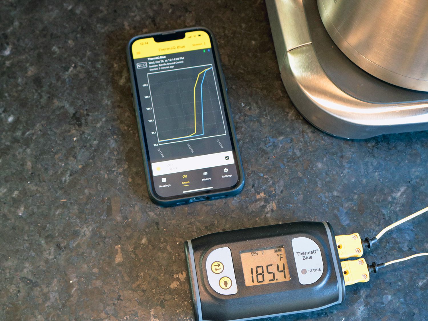 a thermoprobe shows a temperature of 185úF next to an app on a phone graphing temperature rising