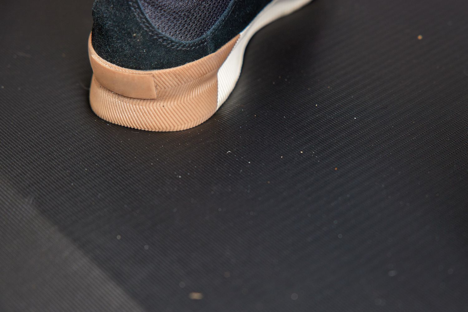 a closeup of the heel of a foot and the surface texture of a standing mat