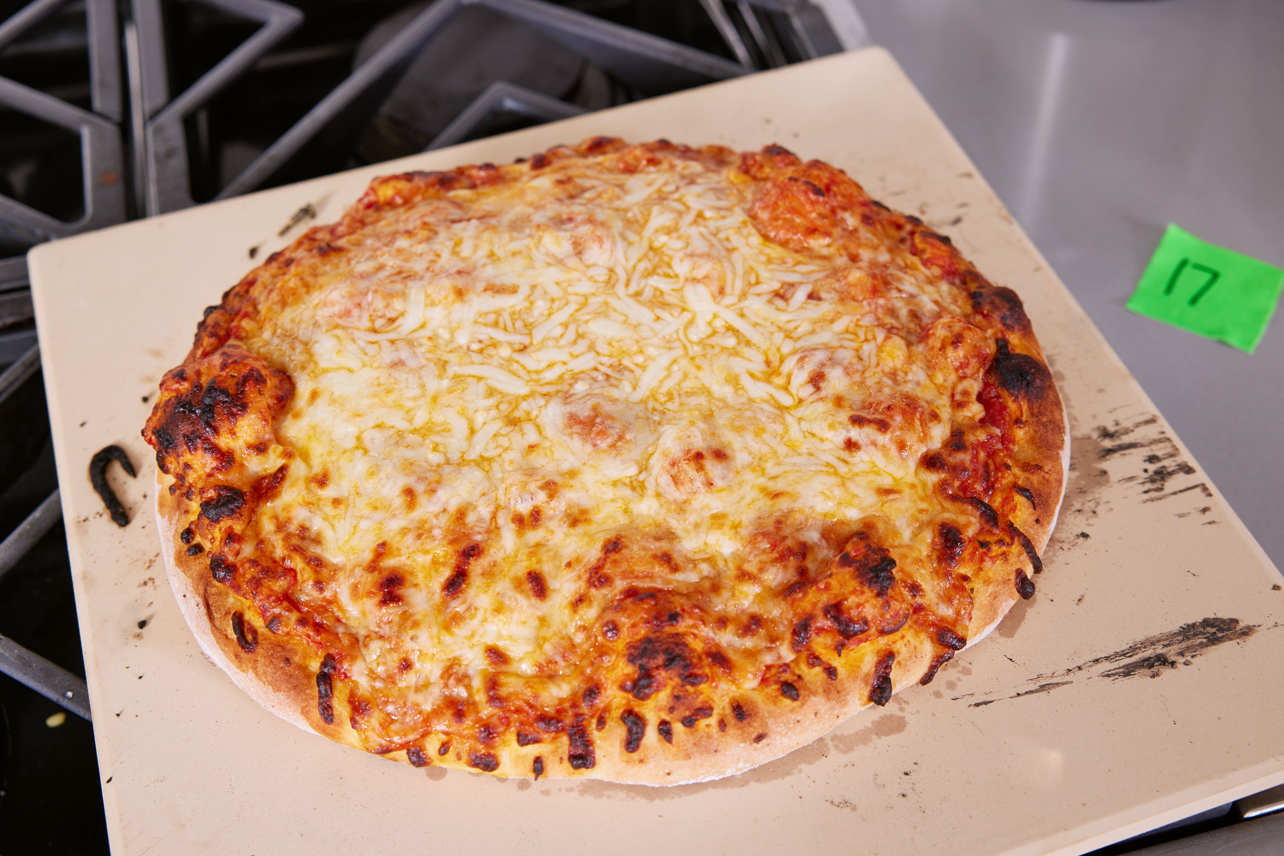 A cooked pizza on a baking stone