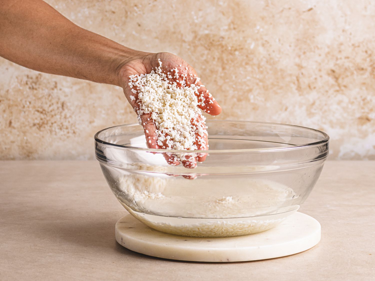 A hand with broken down rice after soaking for 8 hours