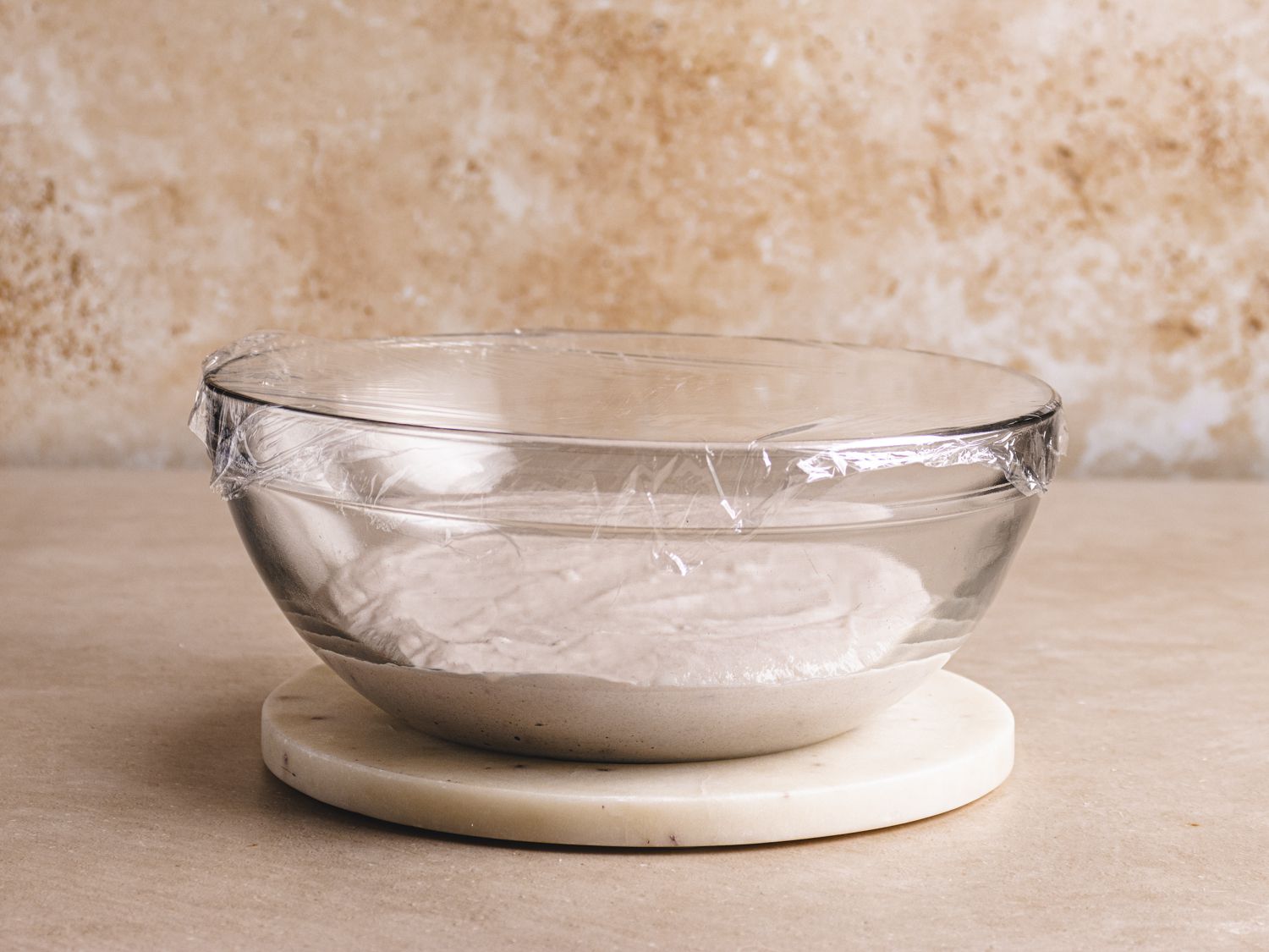 Batter in a plastic bowl covered with plastic wrap