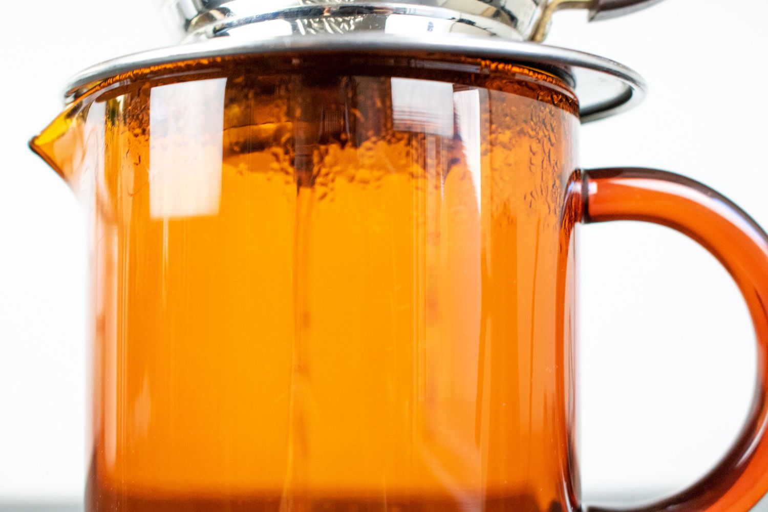 A closeup of pourover coffee brewing into an amber container