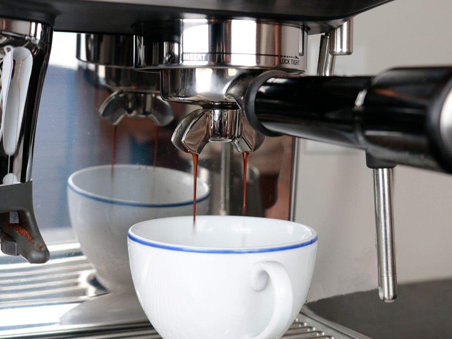 an espresso shot with thick streams is dropping into a cup 