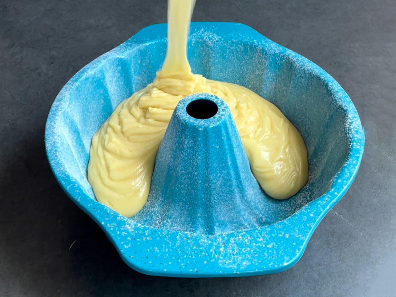 pouring batter for olive oil cake into casaware pan
