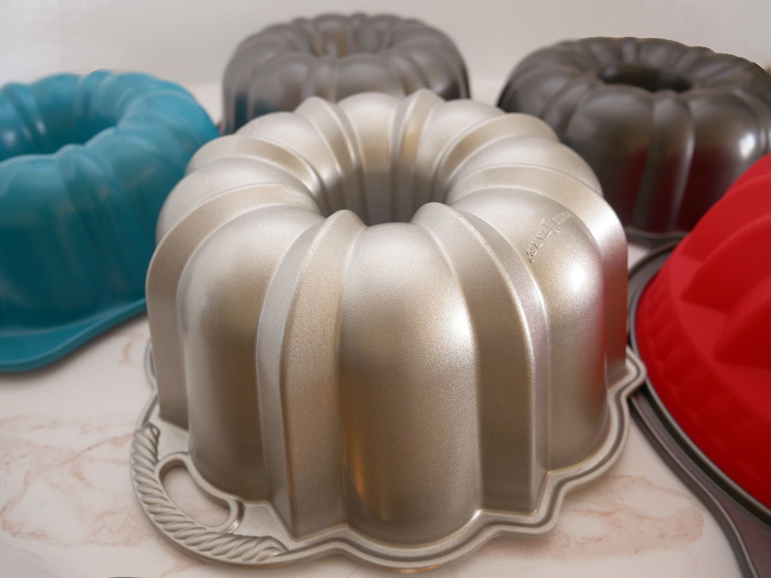 closeup shot of nordic ware anniversary bundt pan with other bundts around them