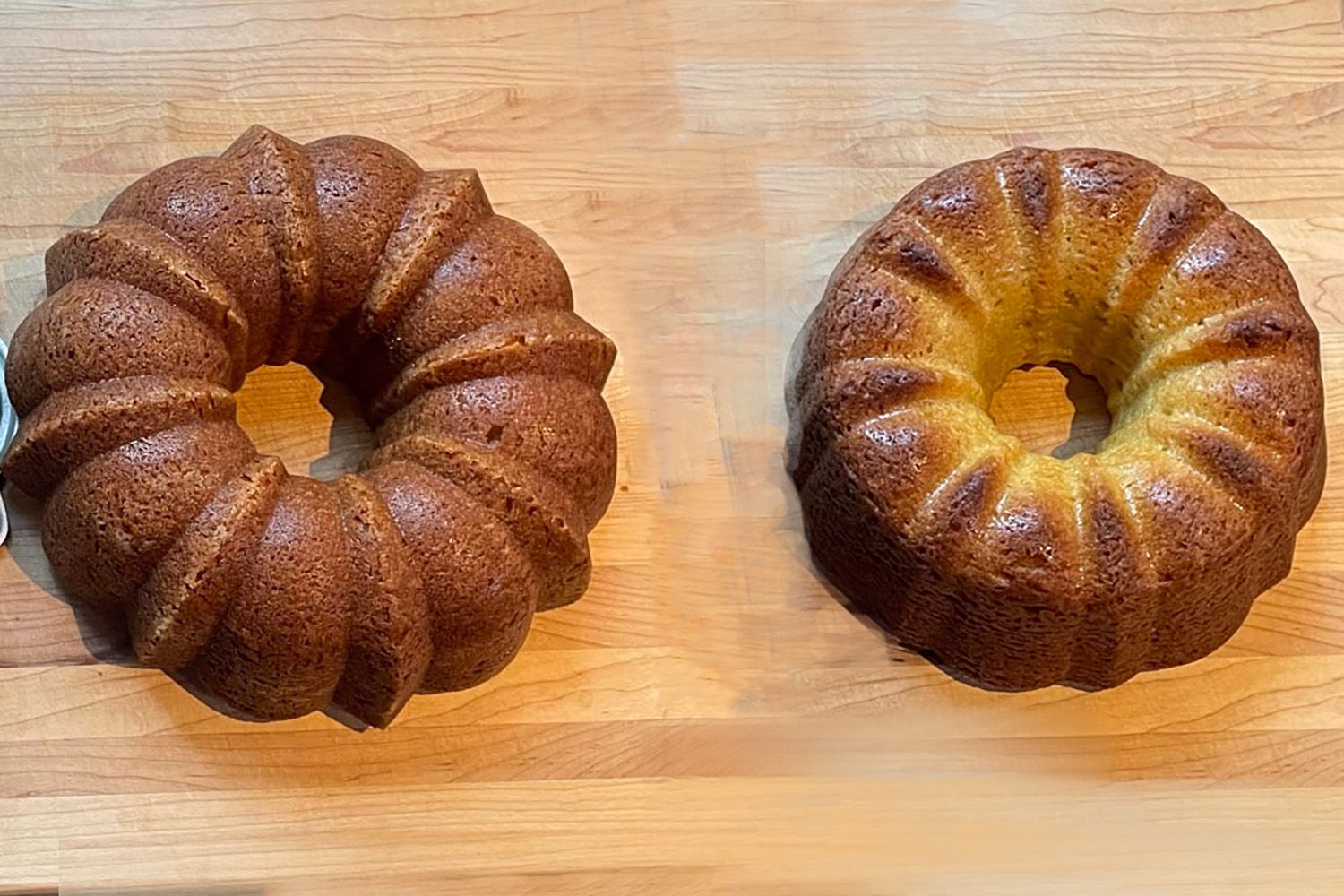 cake baked in aluminum shows even browning while cake baked in silicone is uneven and has darker spots