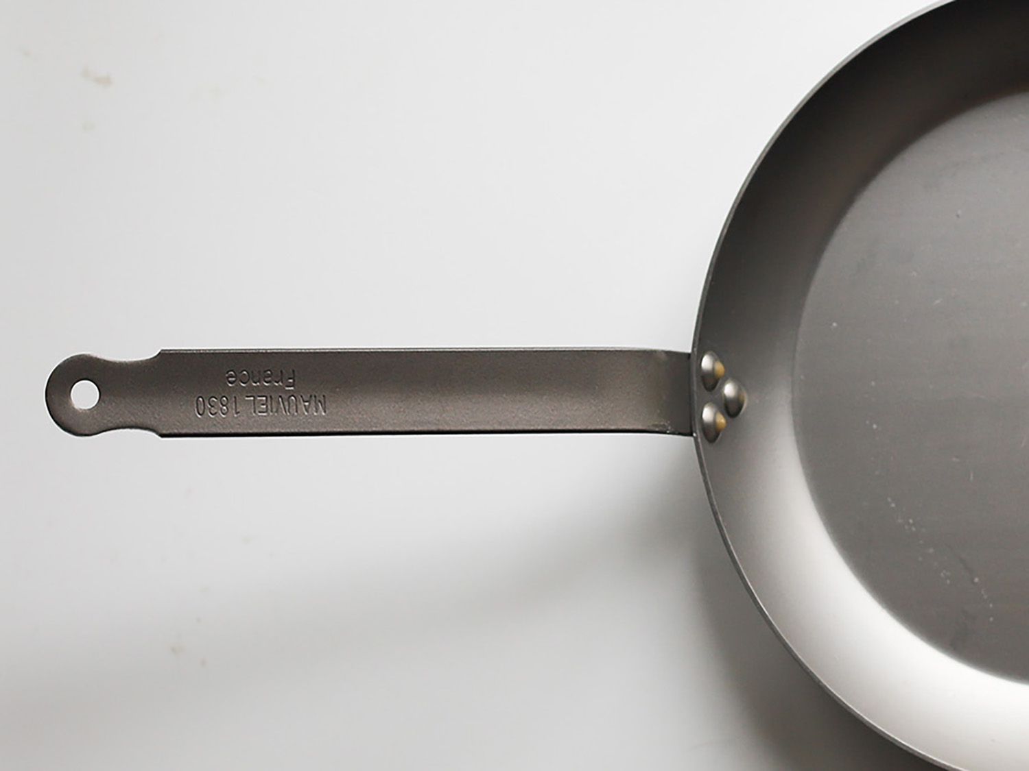 a closeup image of the rounded handle on the Mauviel pan
