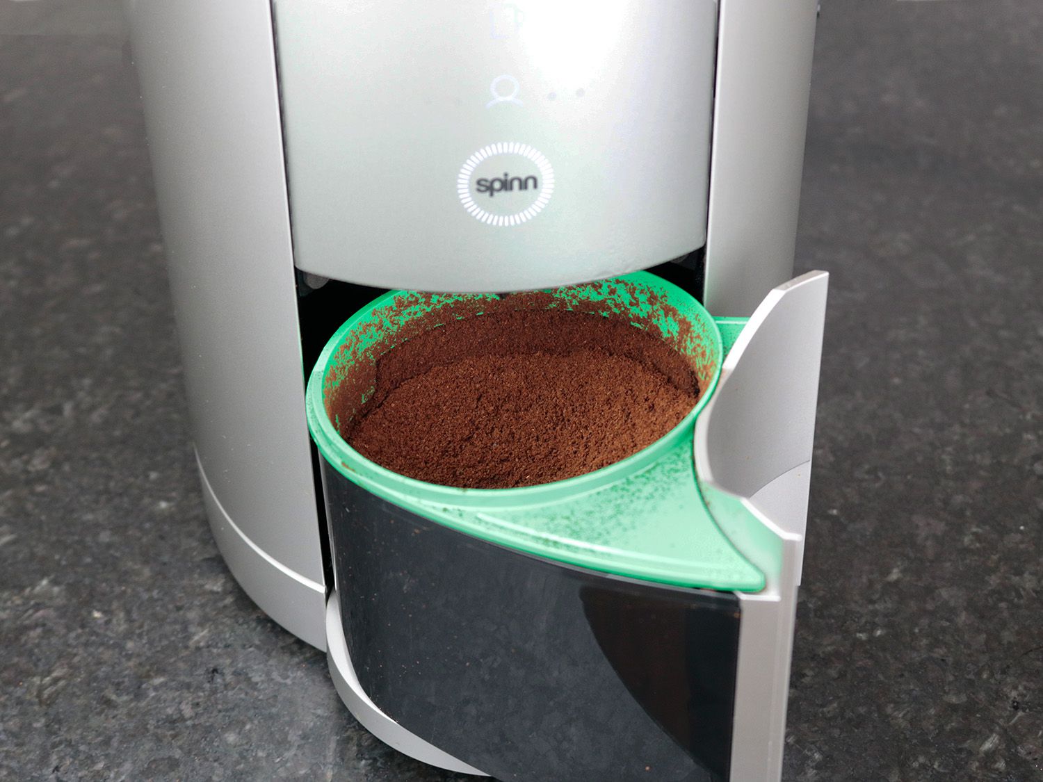 the grounds bin of the spinn coffee maker pulled out and with ground coffee in it
