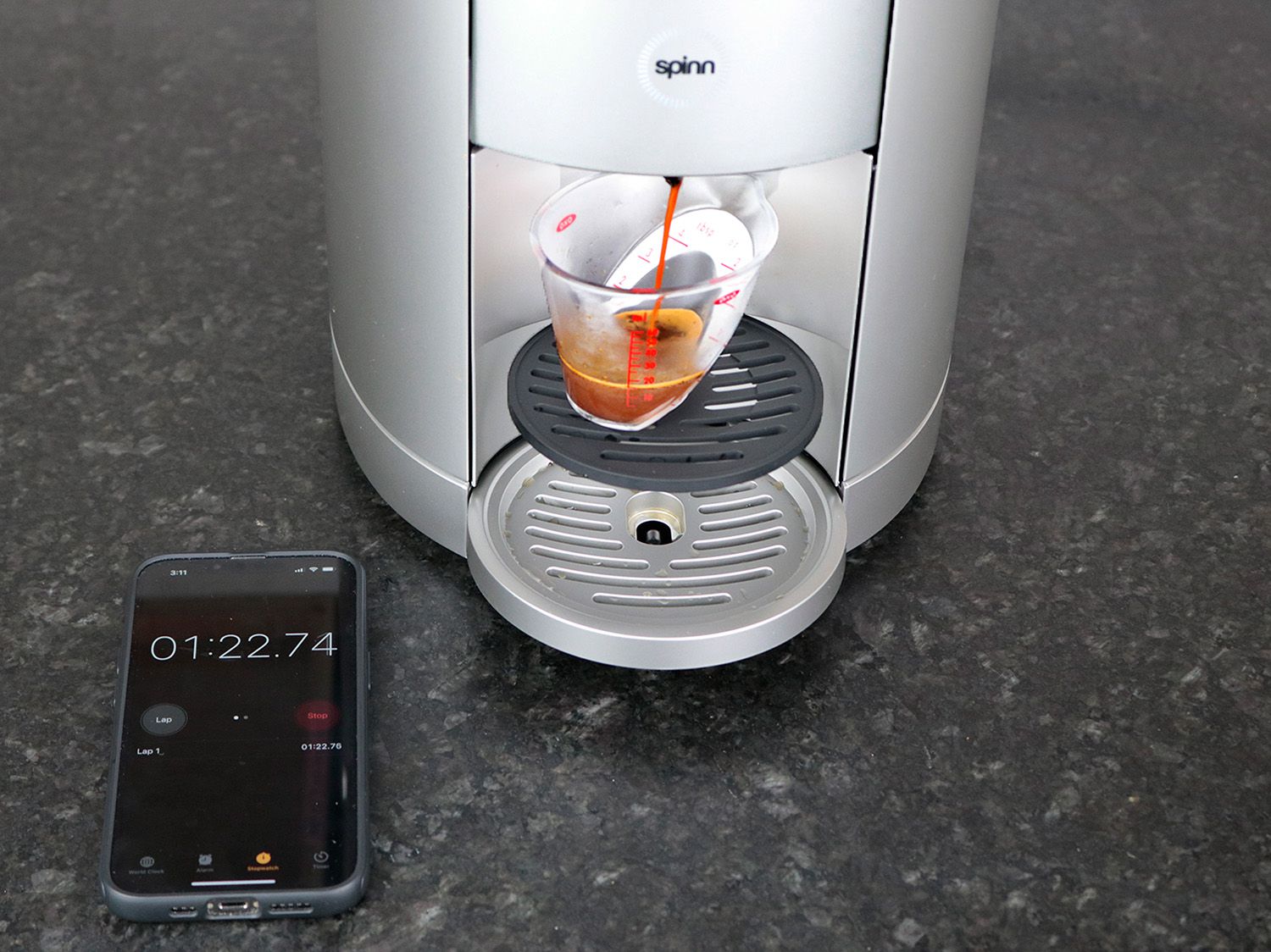 The spinn brewer brewing espresso into a small angled measuring cup