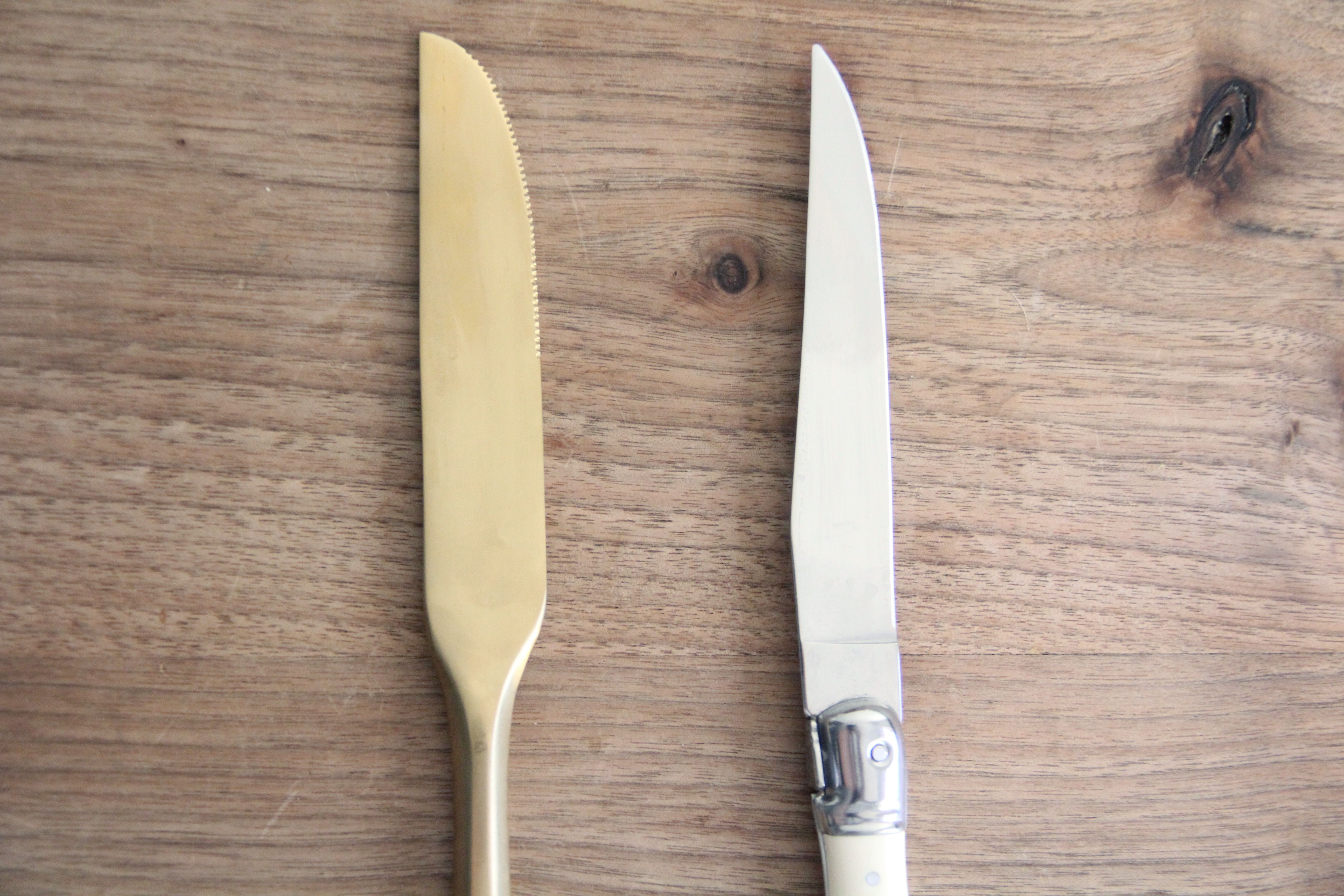 two knives side by side on a wooden surface