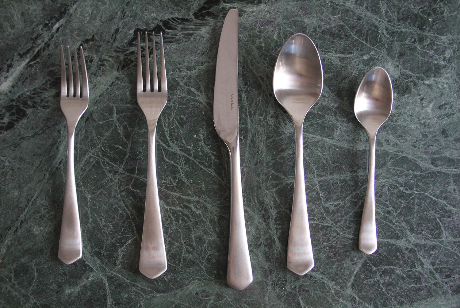A silverware set on a blueish-grey marbled surface