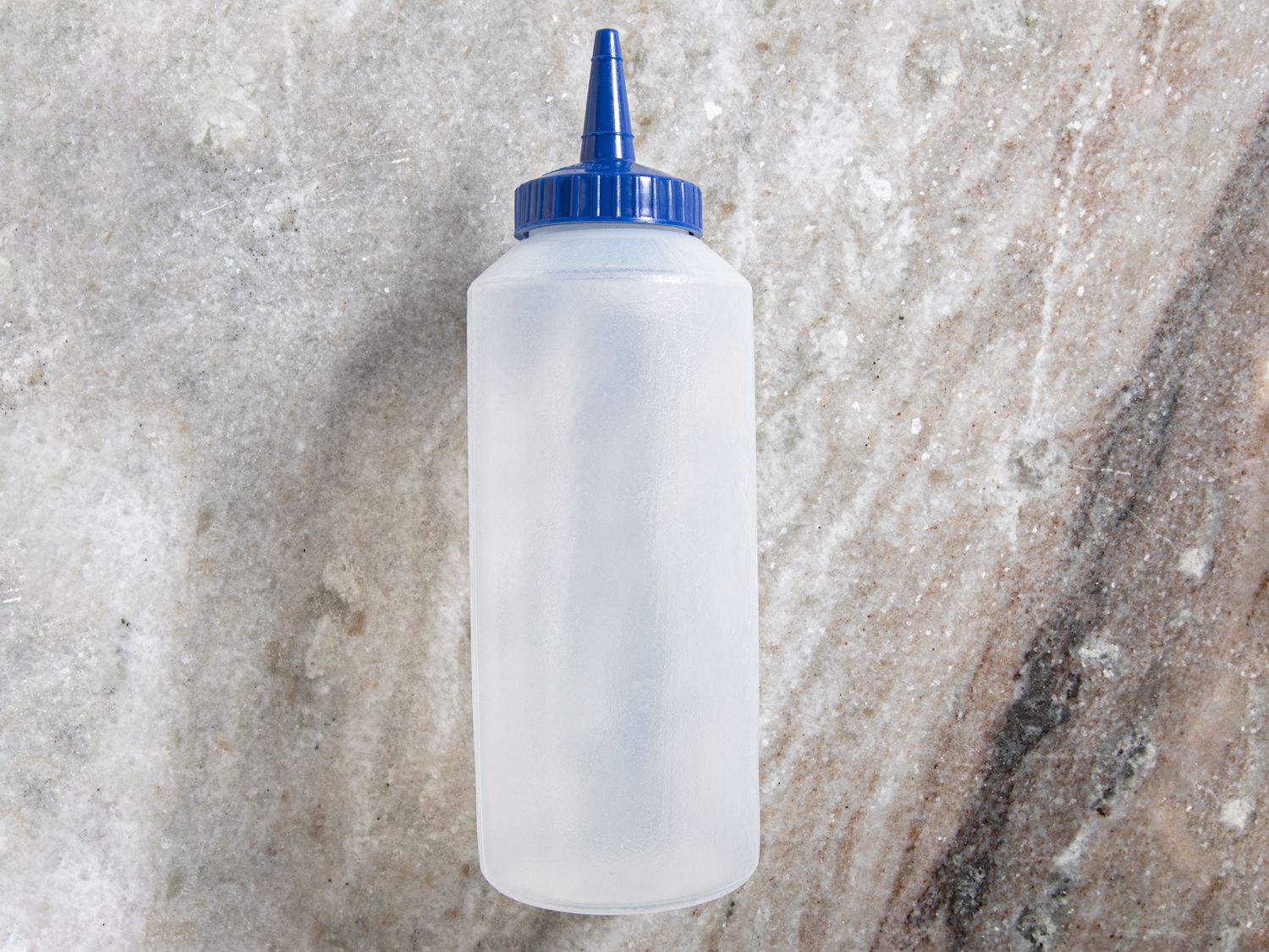 Vollrath squeeze bottle on a grey marble countertop