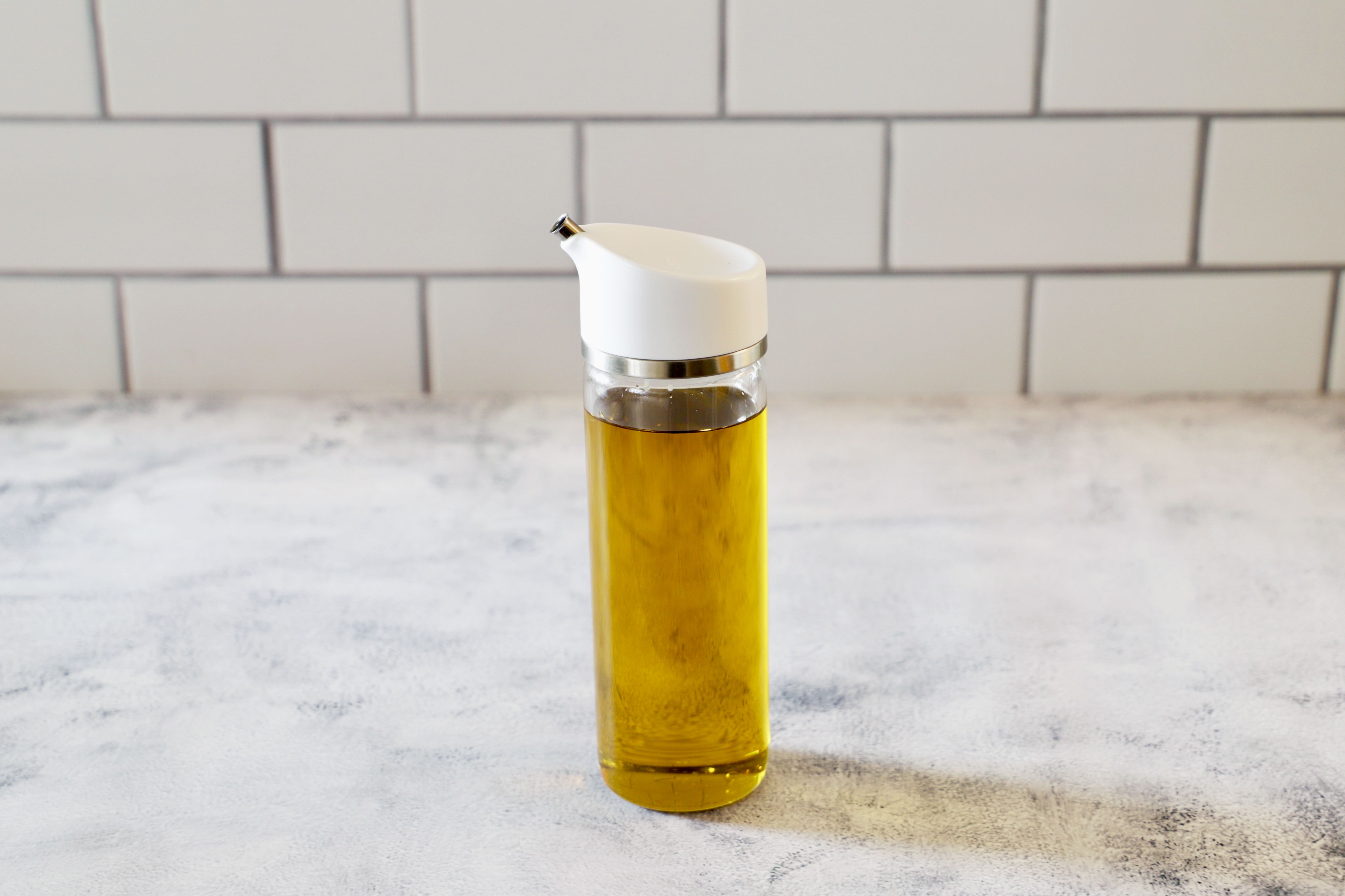 the OXO oil dispenser on a textured surface.