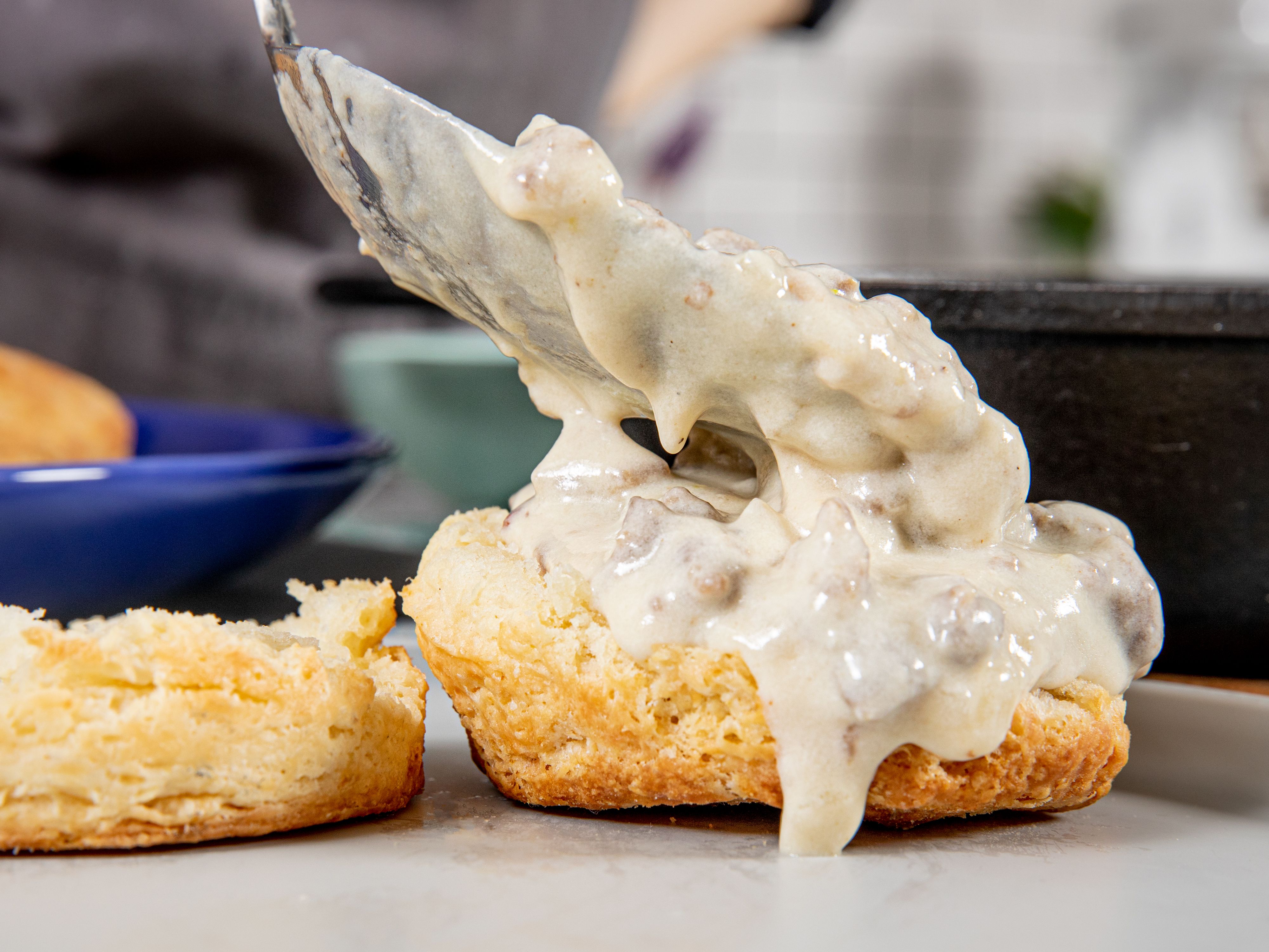 Spooning gravy over biscuits