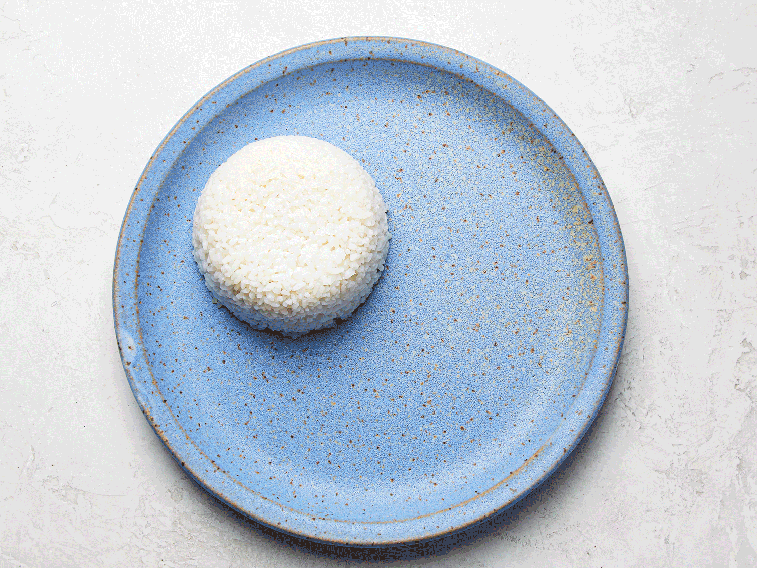 Overhead view of broken rice dish being assembled