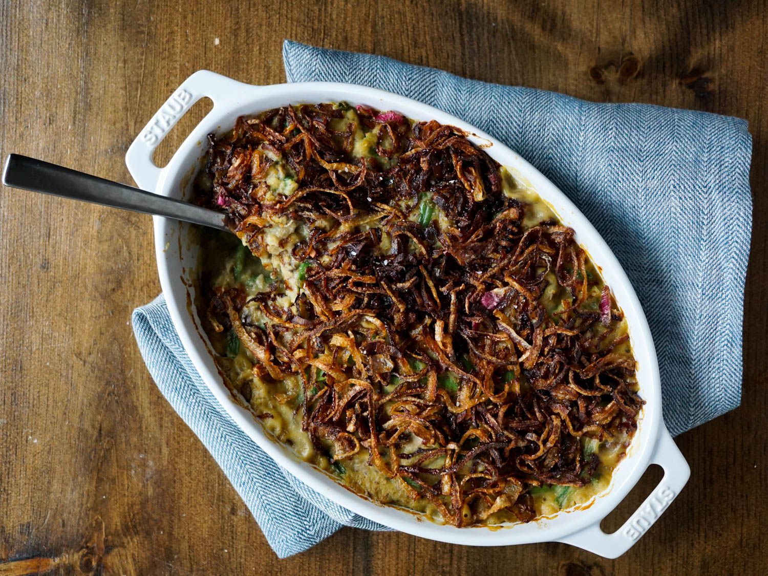 Overhead shot of finished green bean casserole in a white oval dish