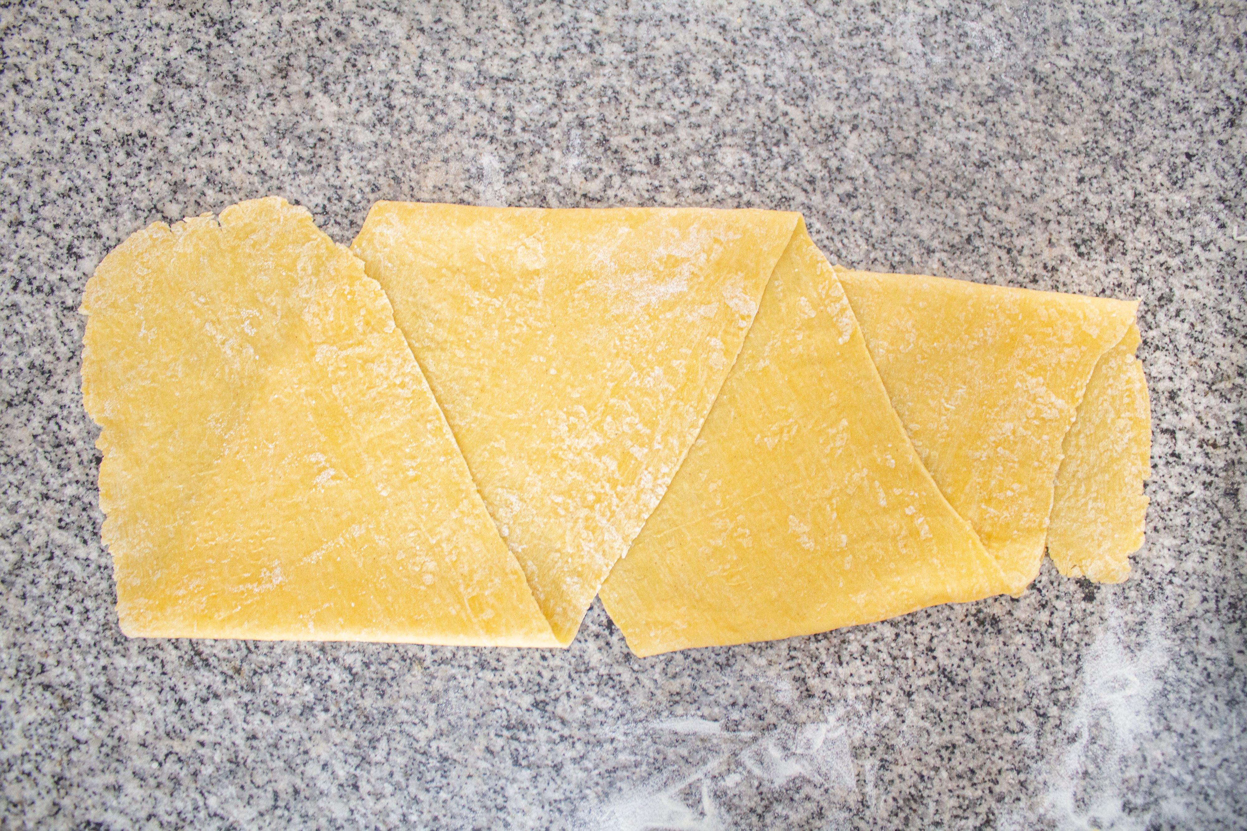Overhead view of dough rolled into a thinner piece