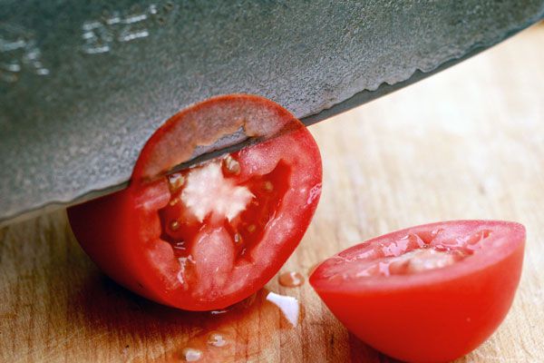 Testing the sharpness of a knife by thinly slicing a tomato