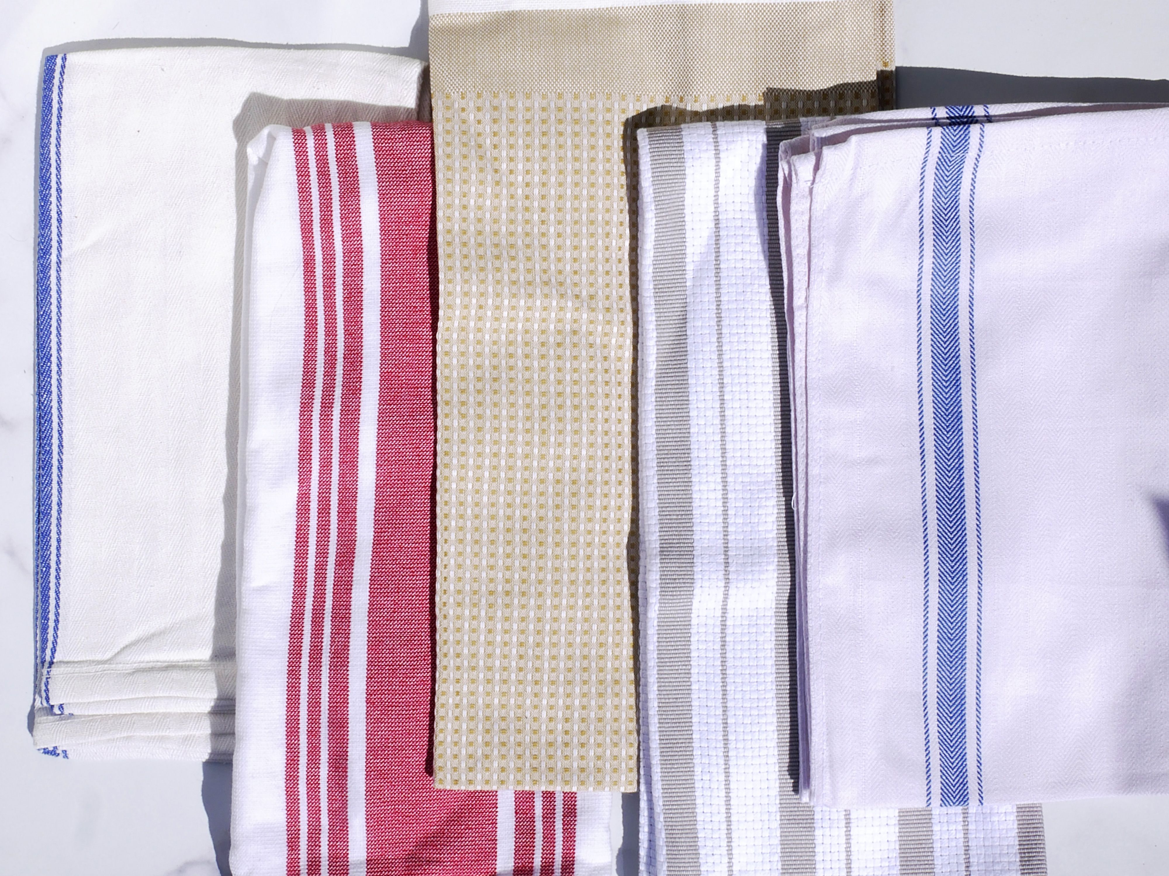 Five dish towels on a marble surface