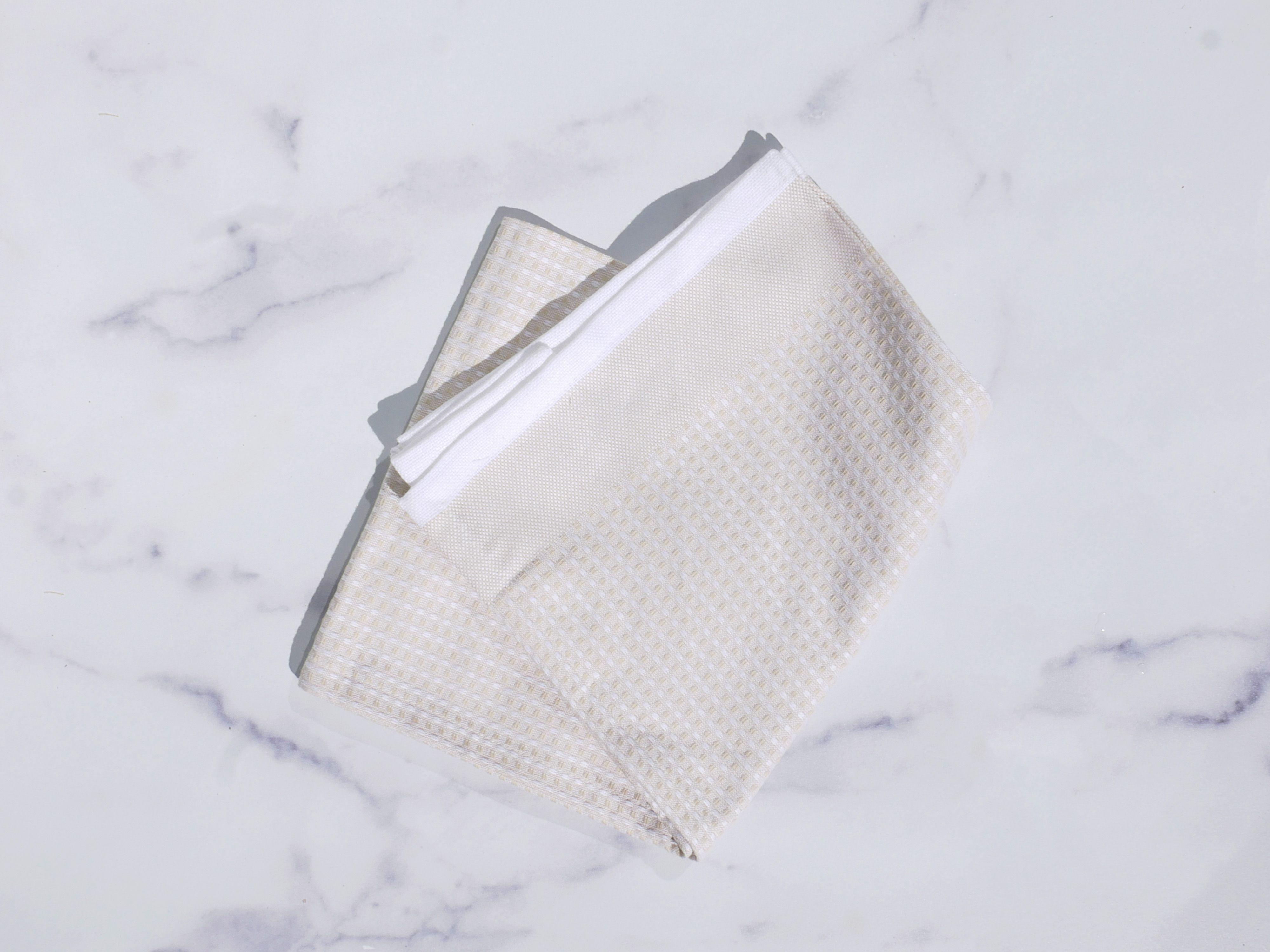 A biege dish towel on a marble surface