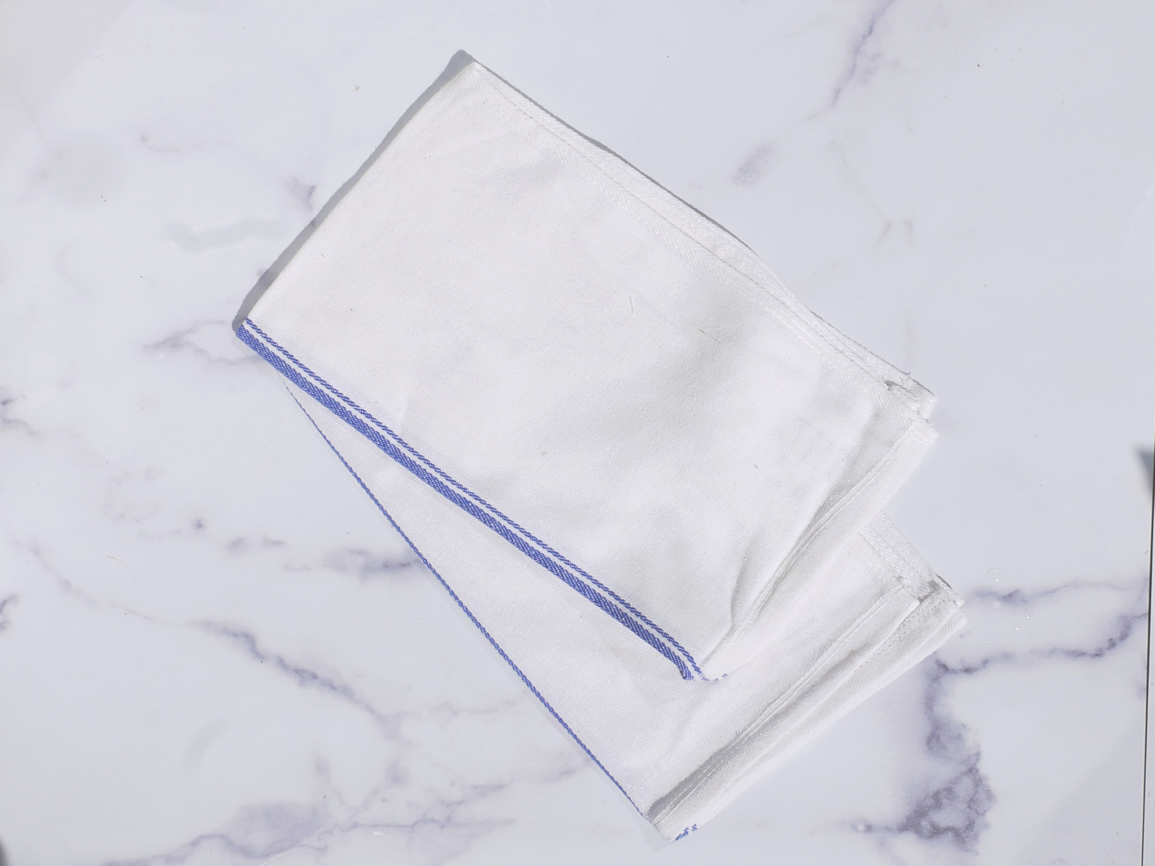 A blue and white towel on a marble surface