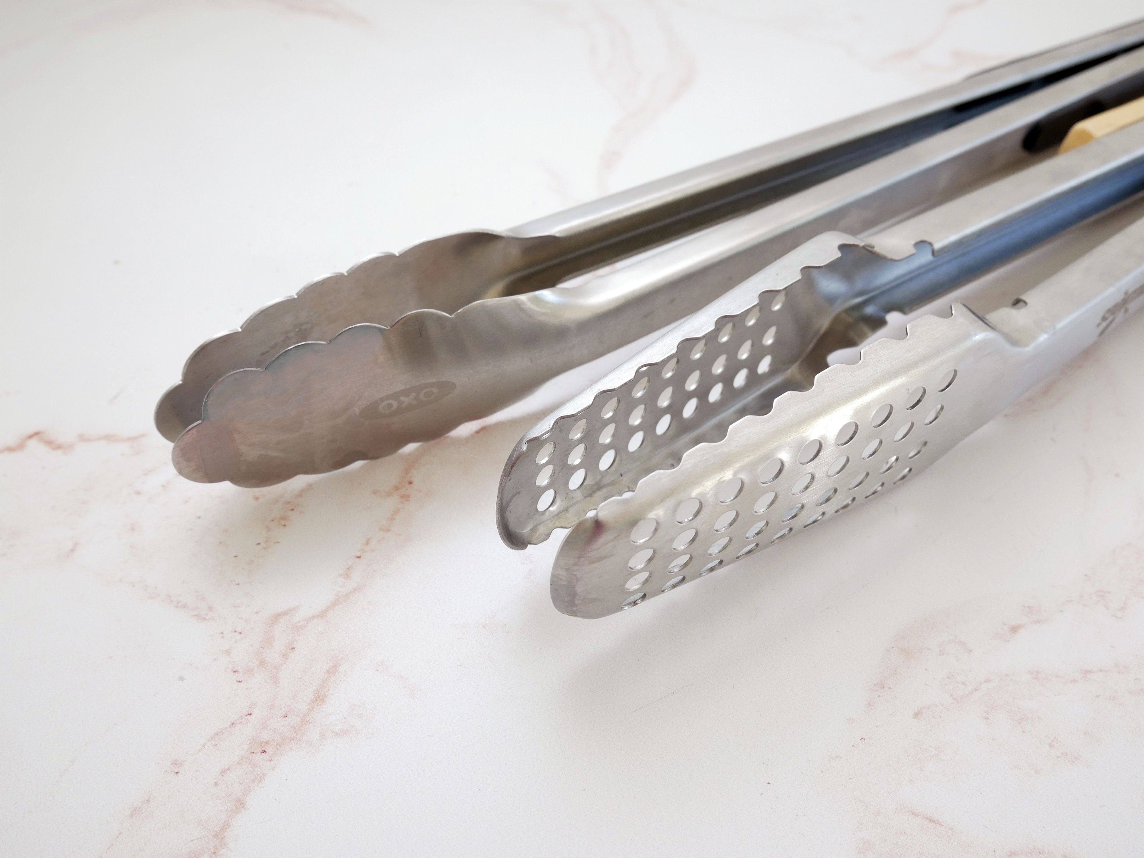 scalloped, oval tong heads next to ridged, squared off tong heads