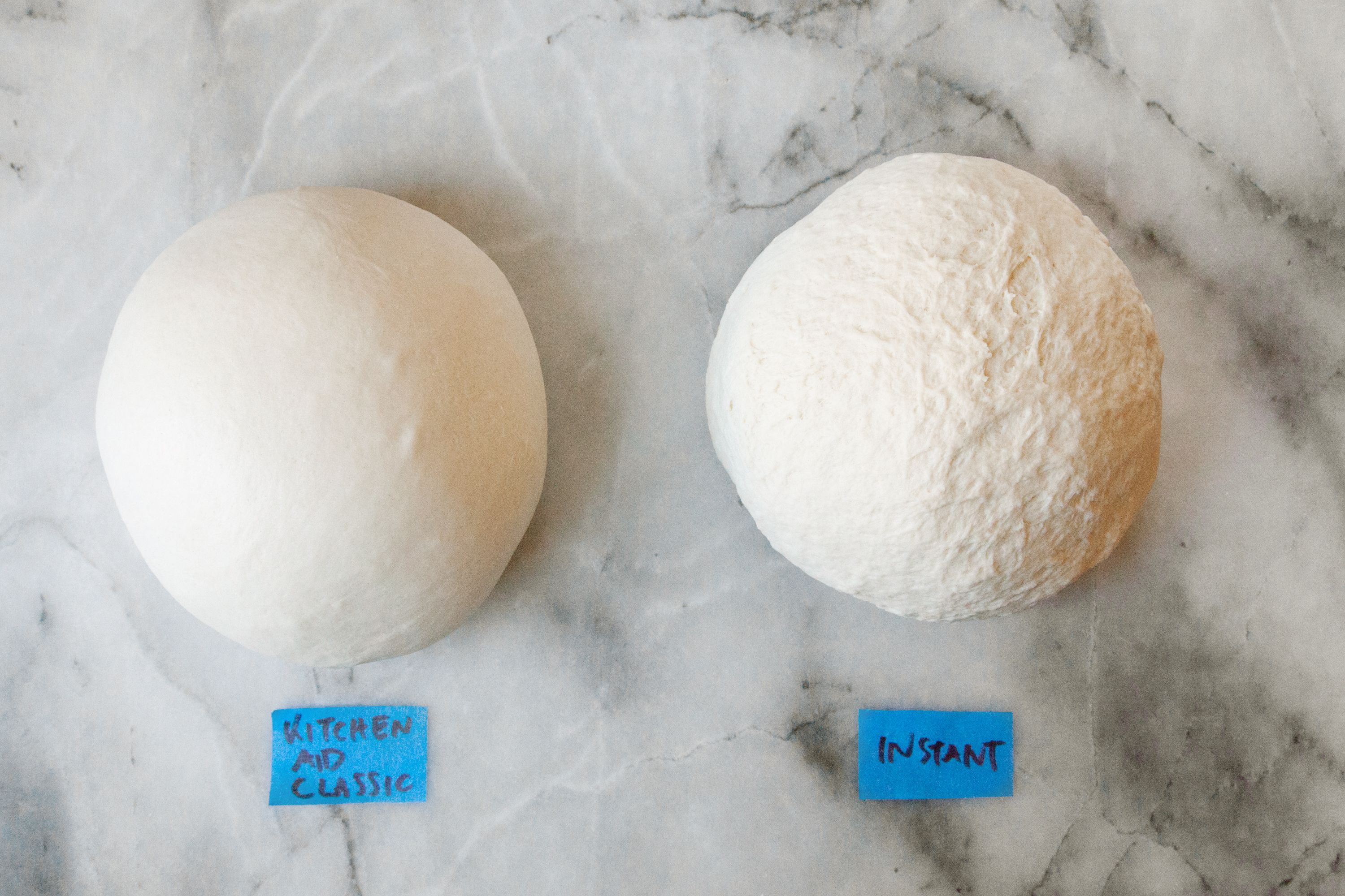 Two dough balls on a marble surface
