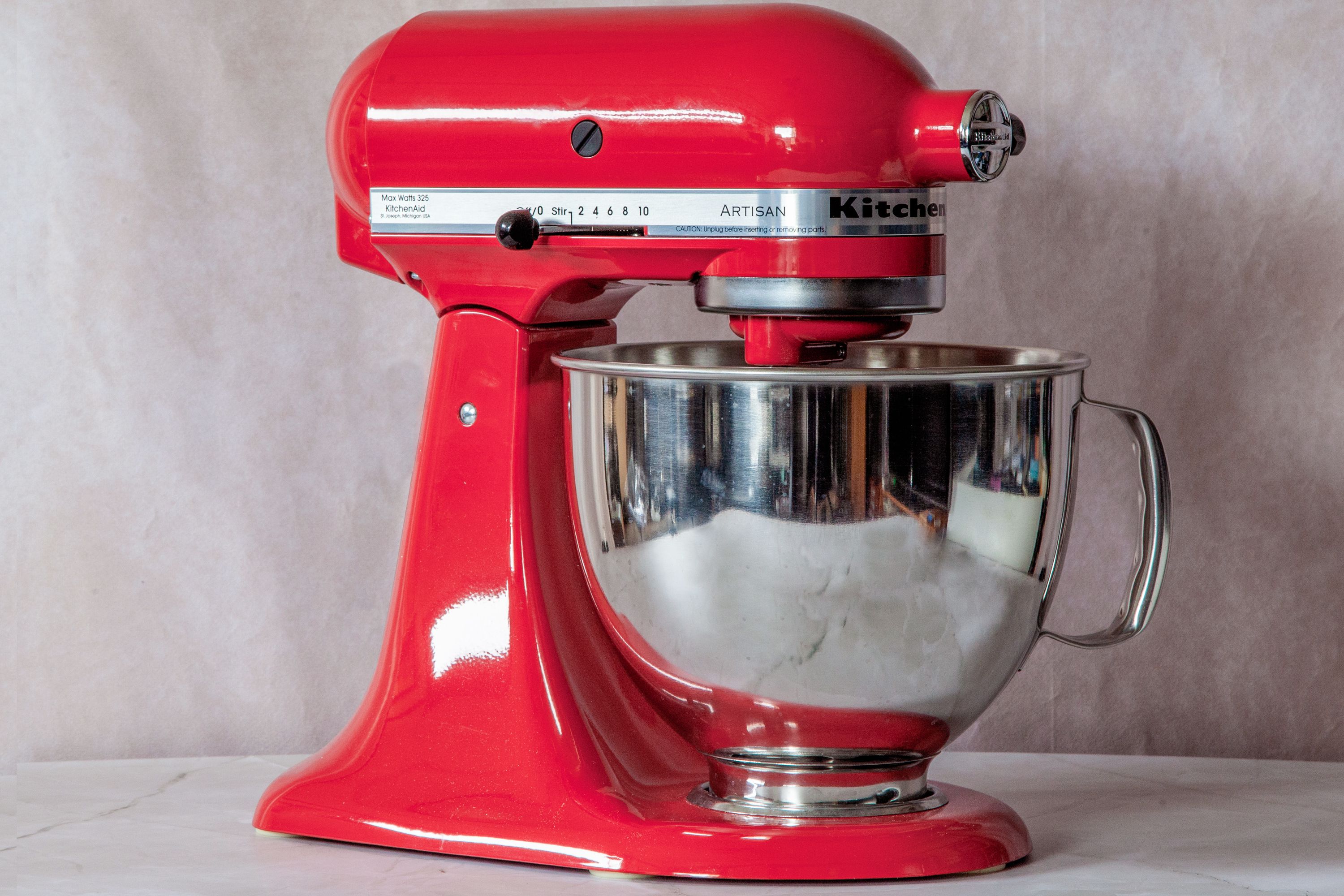 a red stand mixer on a marble surface