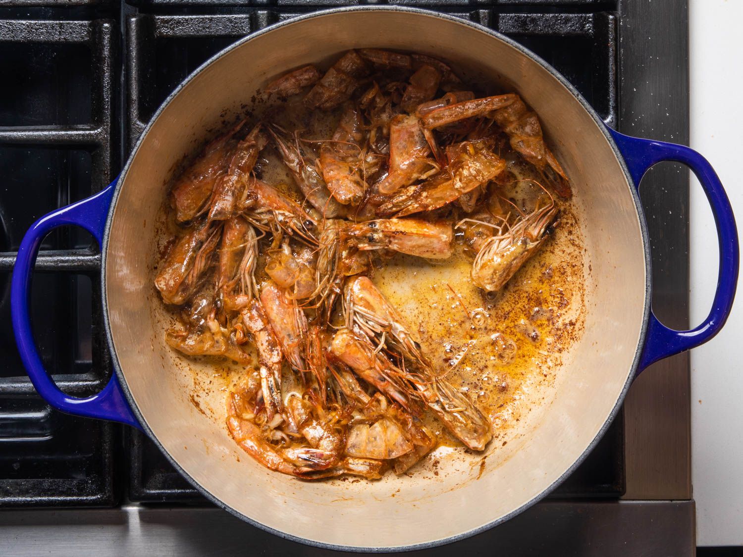 Shrimp shells and heads browning in a Dutch oven.
