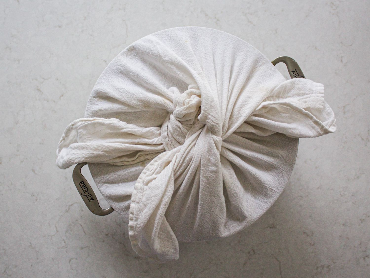 Overhead view of lid of pot wrapped in towel