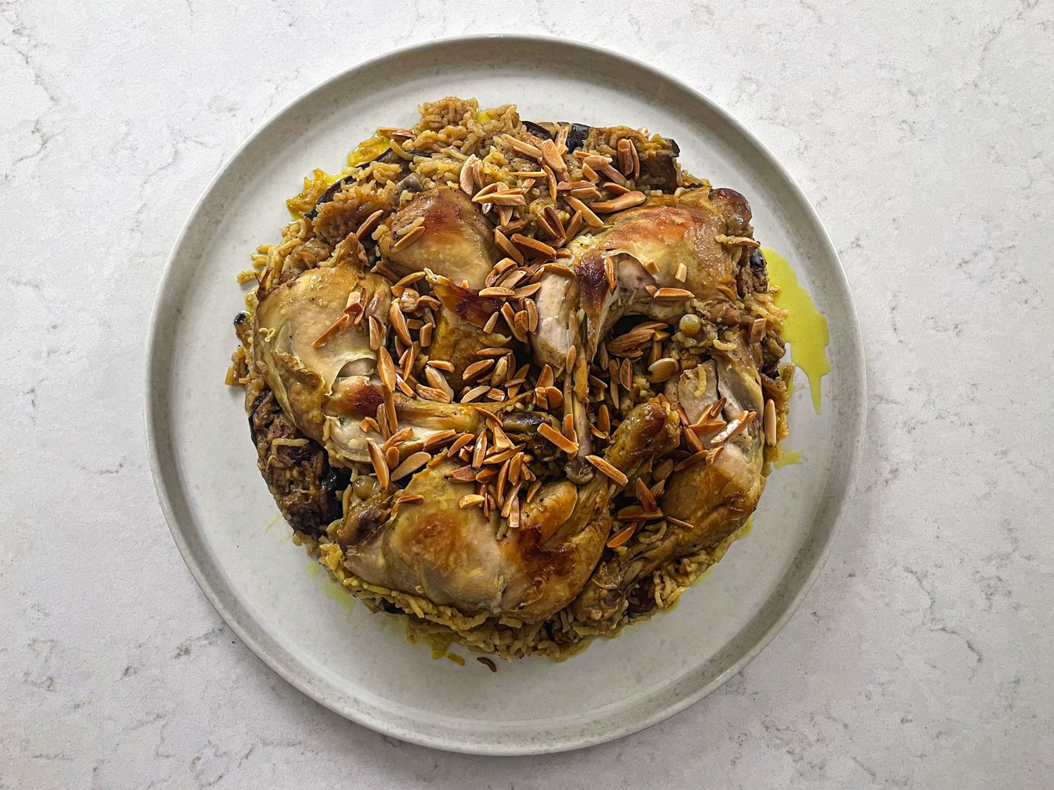Finished Maqlubeh topped with almonds on a plate