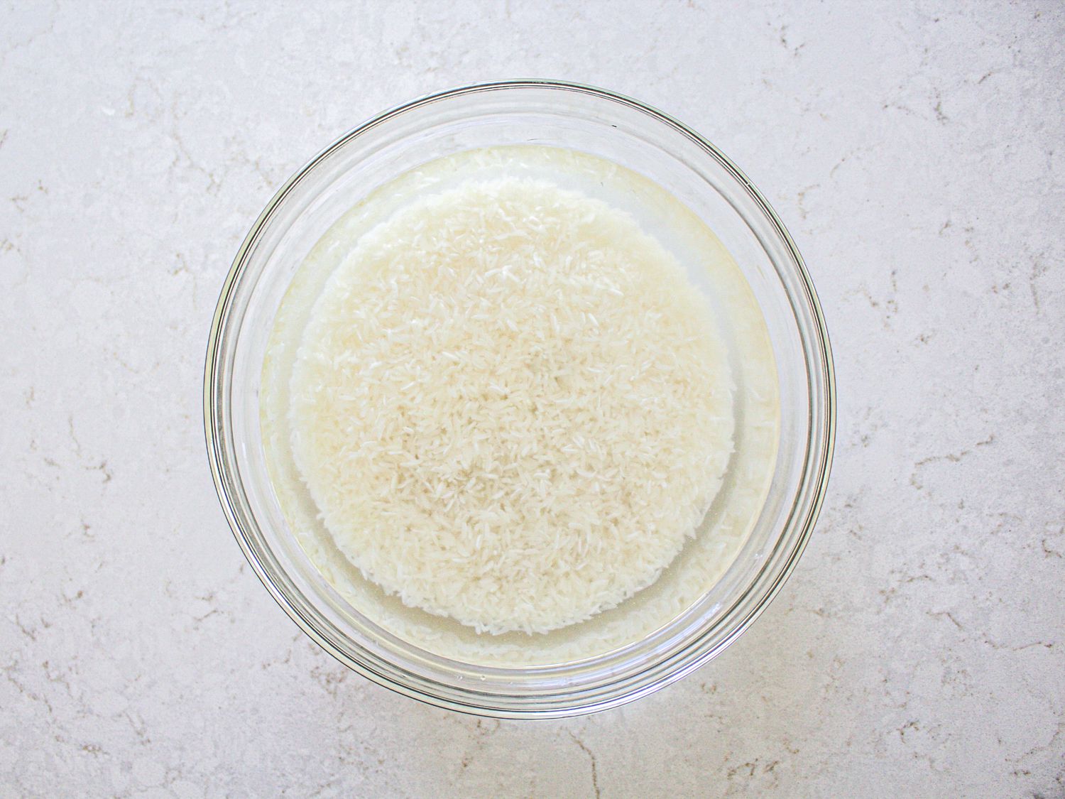 Washed rice in a clear bowl