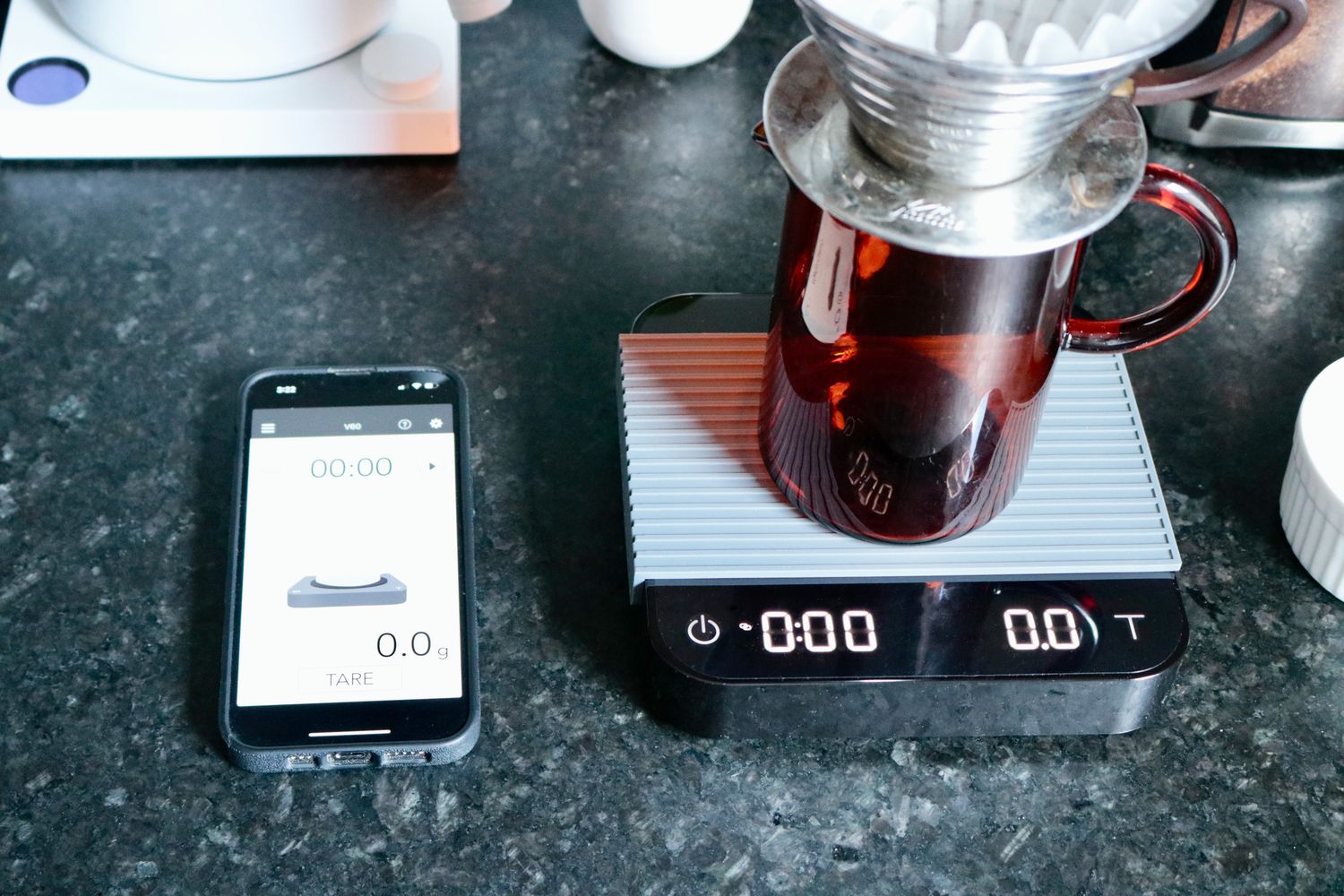 the acaia pearl with app open on phone next to it