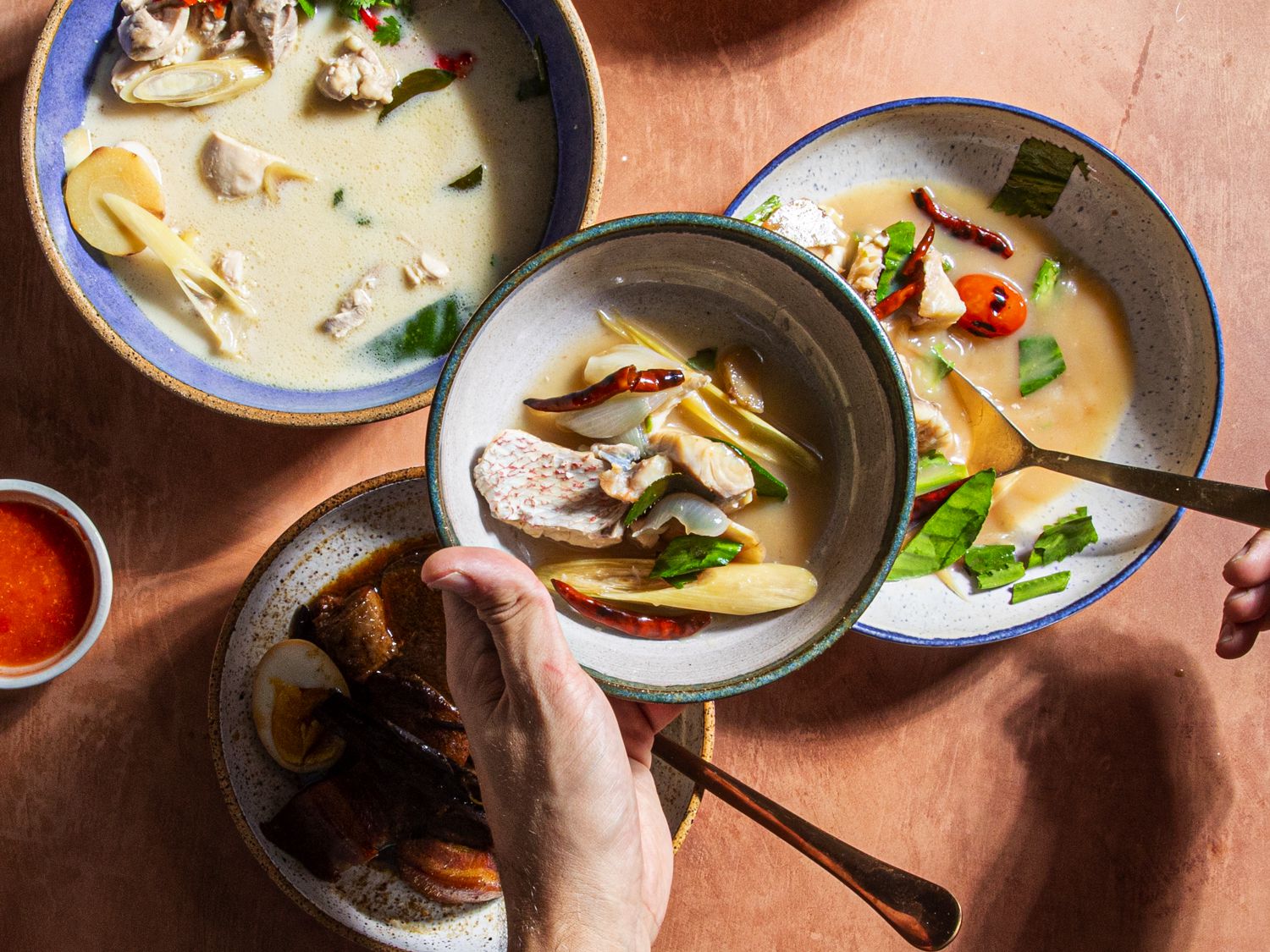 Someone getting a serving of Tom Yum Pla soup 