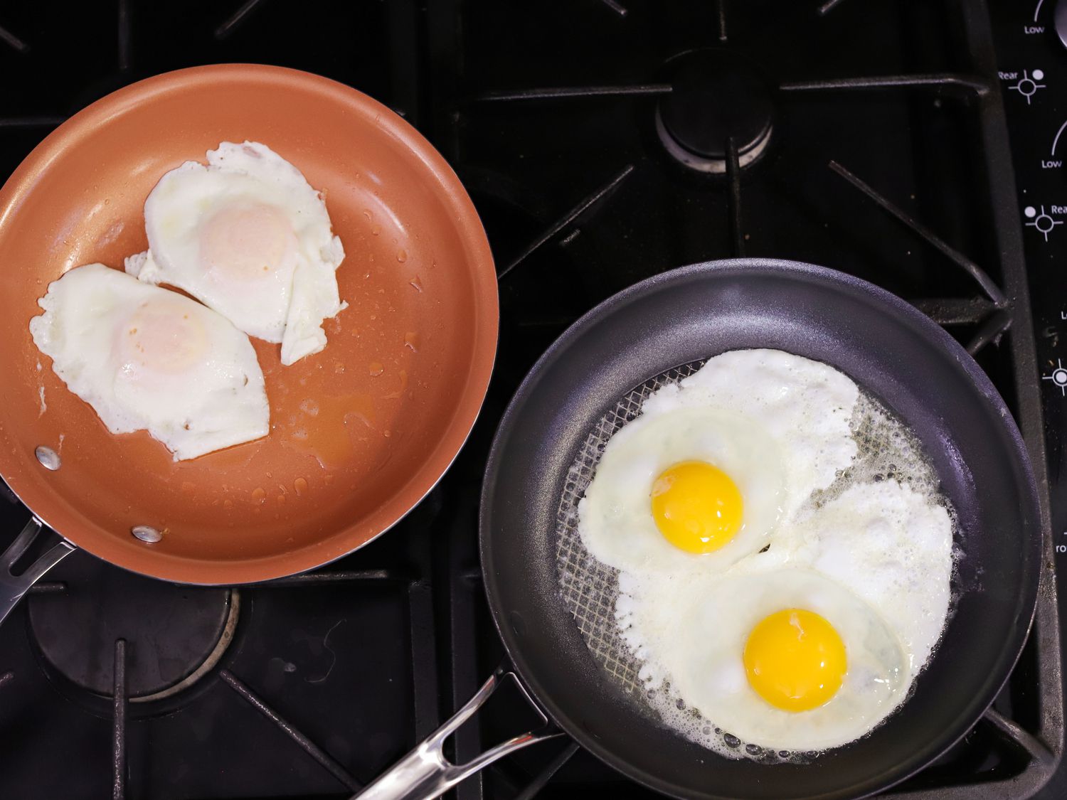 two nonstick skillets frying two eggs each