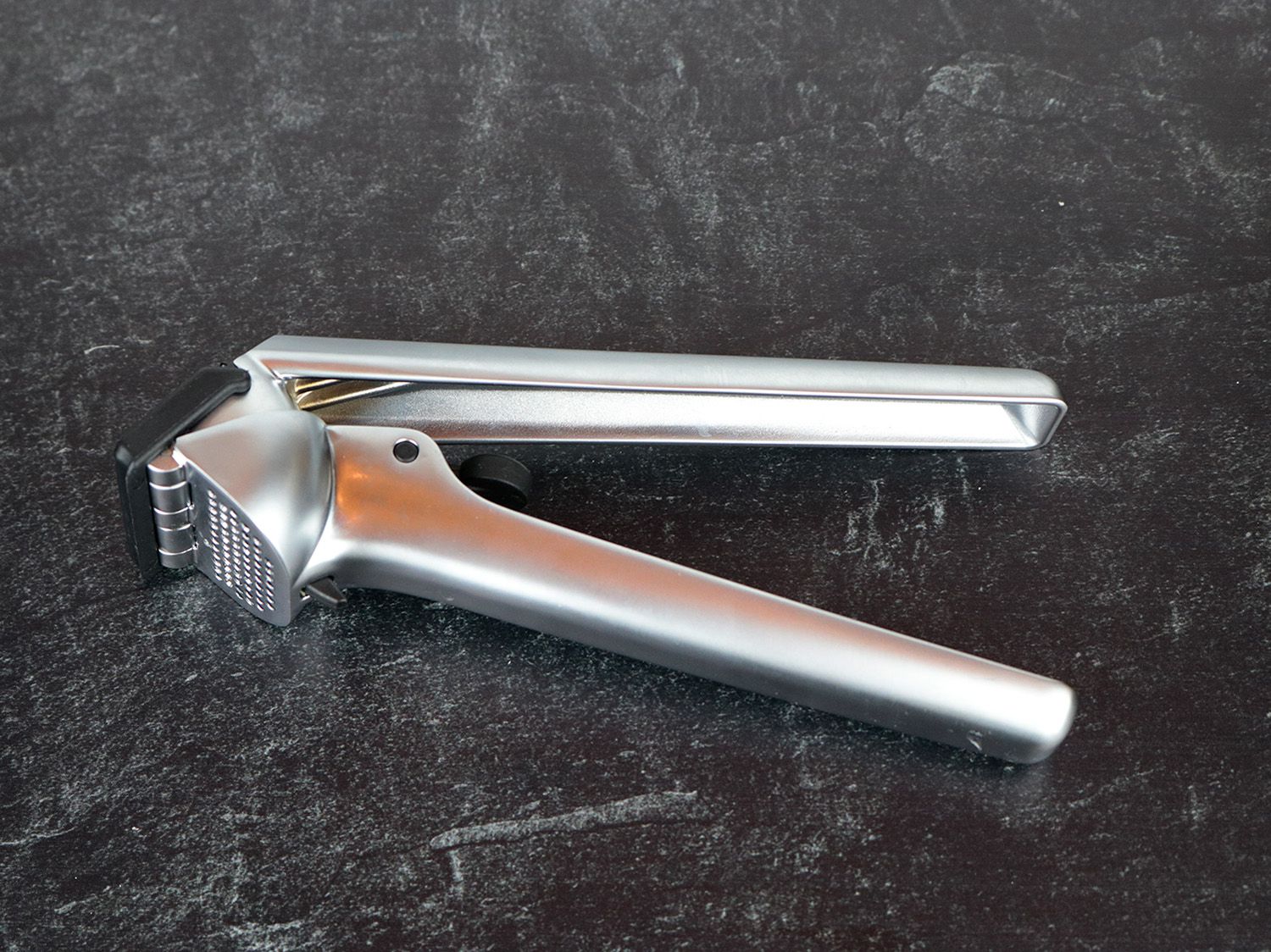 the Dreamfarm Garject garlic press resting on a counter