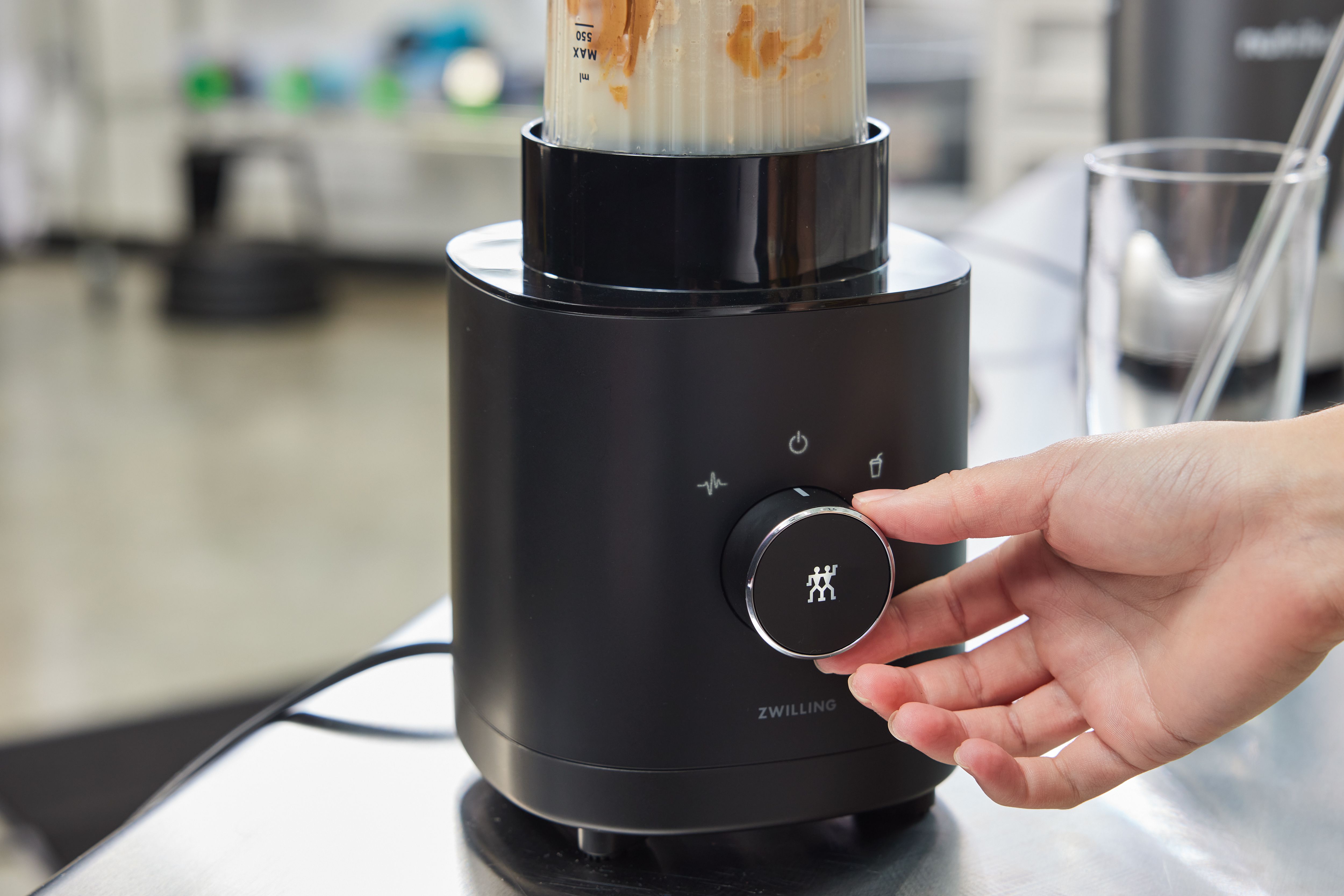 a closeup of someone adjusting the dial on the Zwilling personal blender