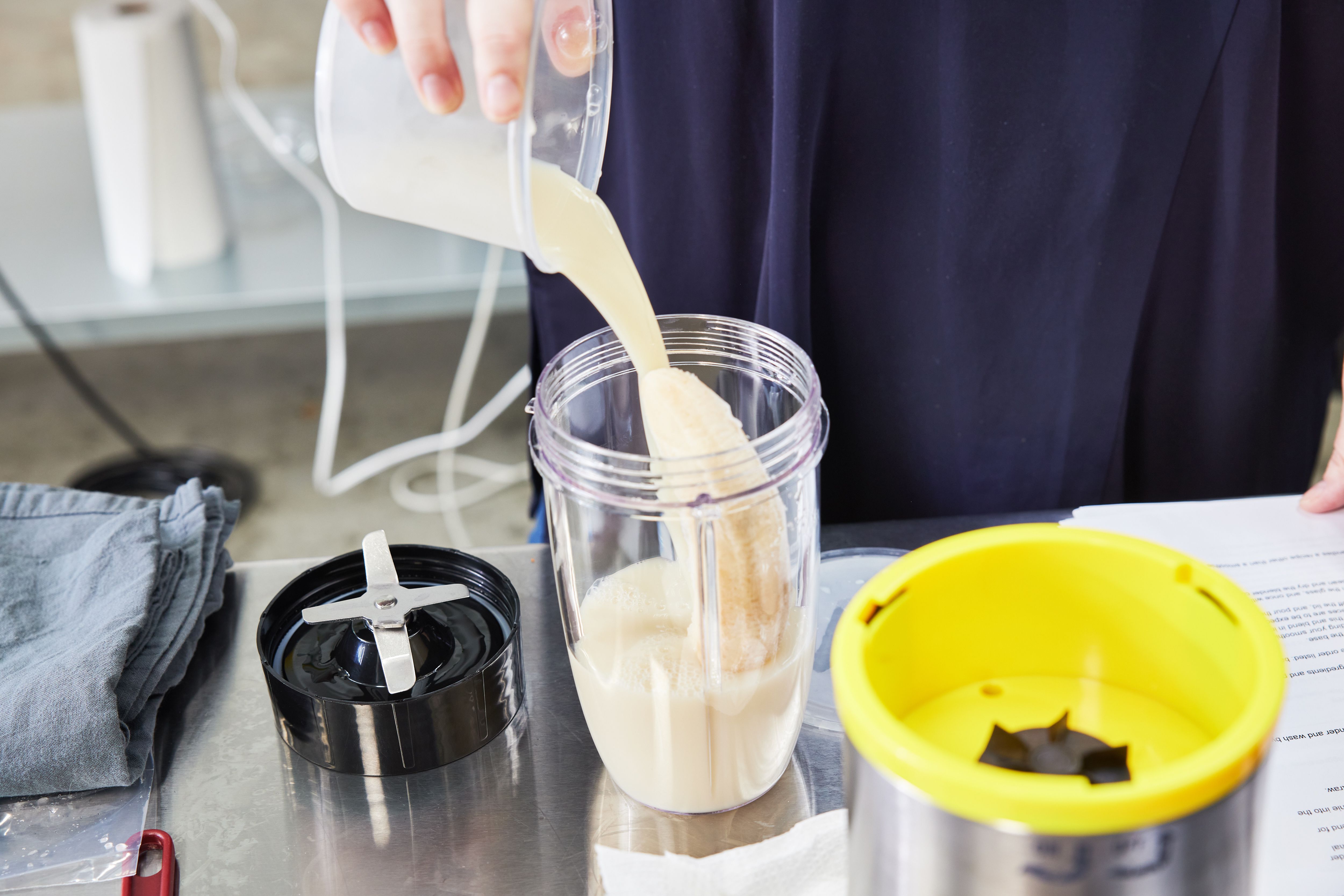 adding milk to a personal blender jar