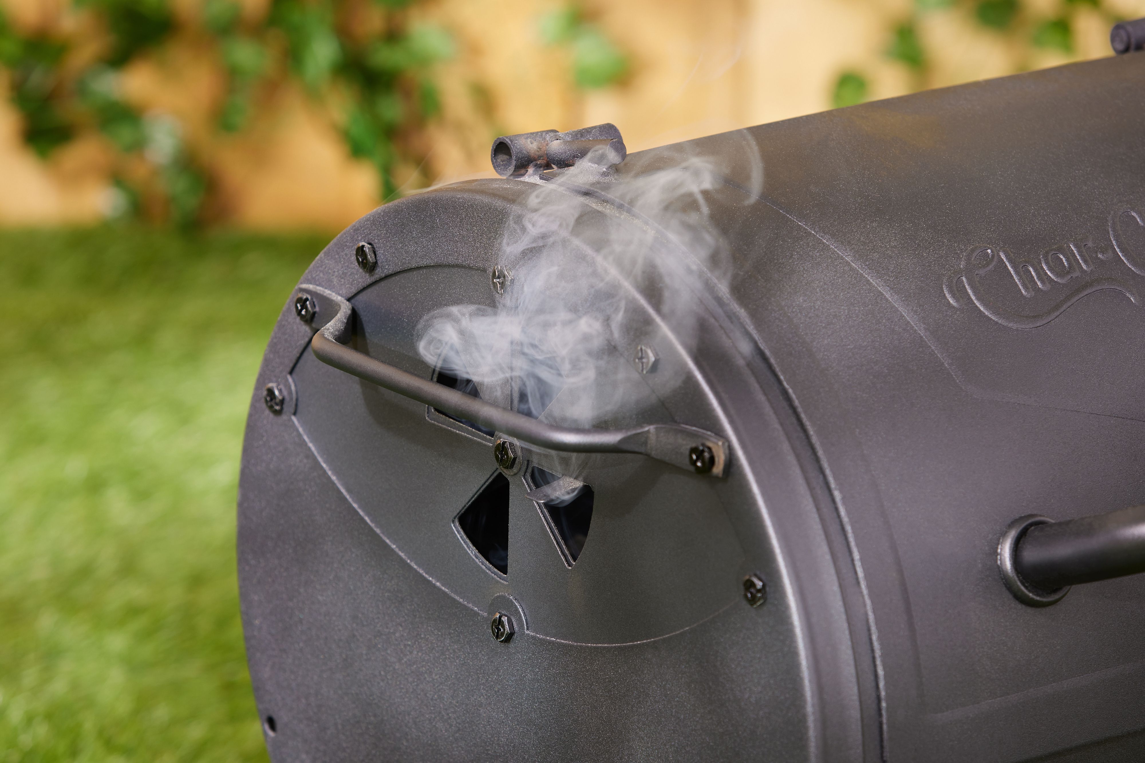 A closeup look at smoke exiting a portable charcoal grill