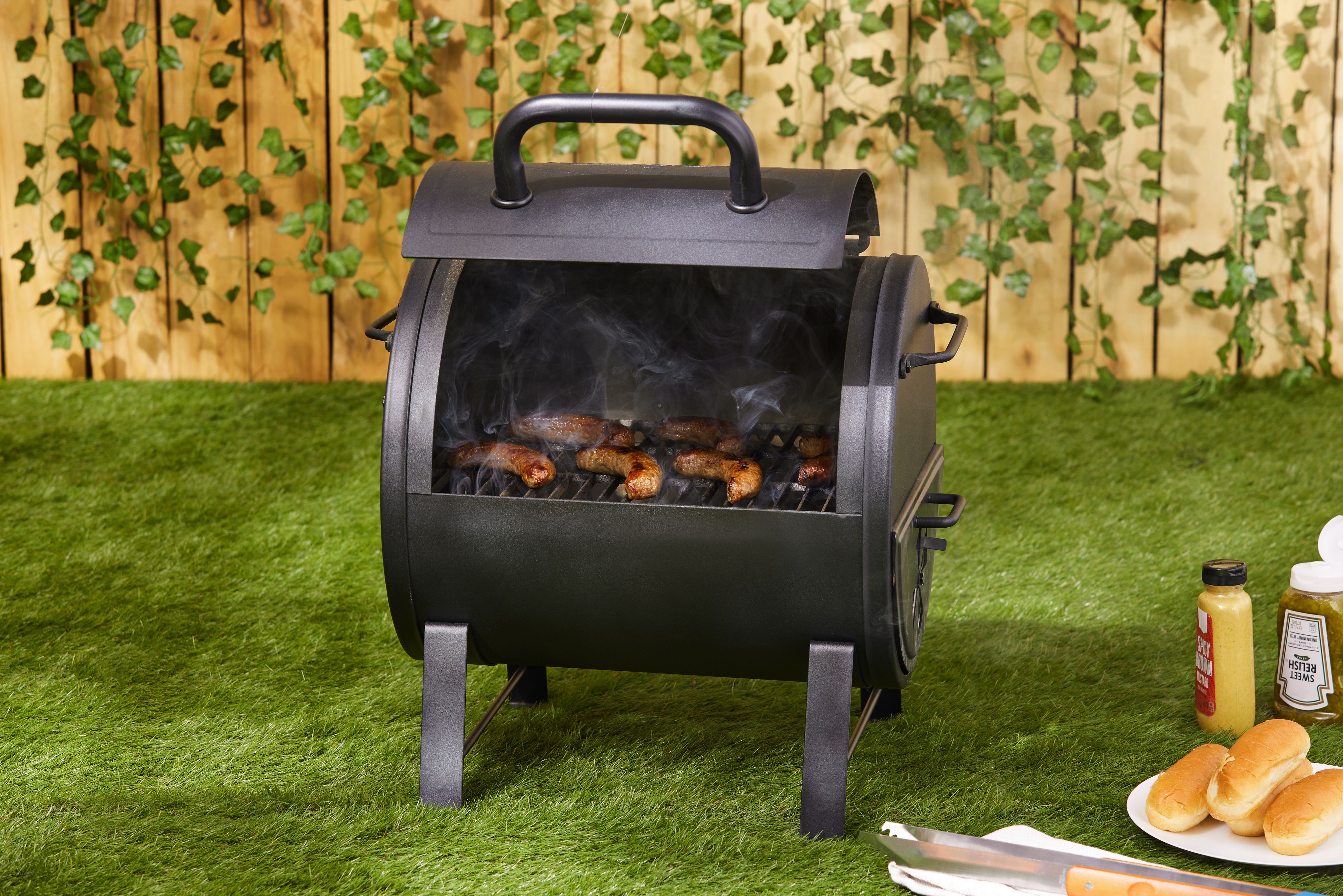 sausages cooking on a portable charcoal grill
