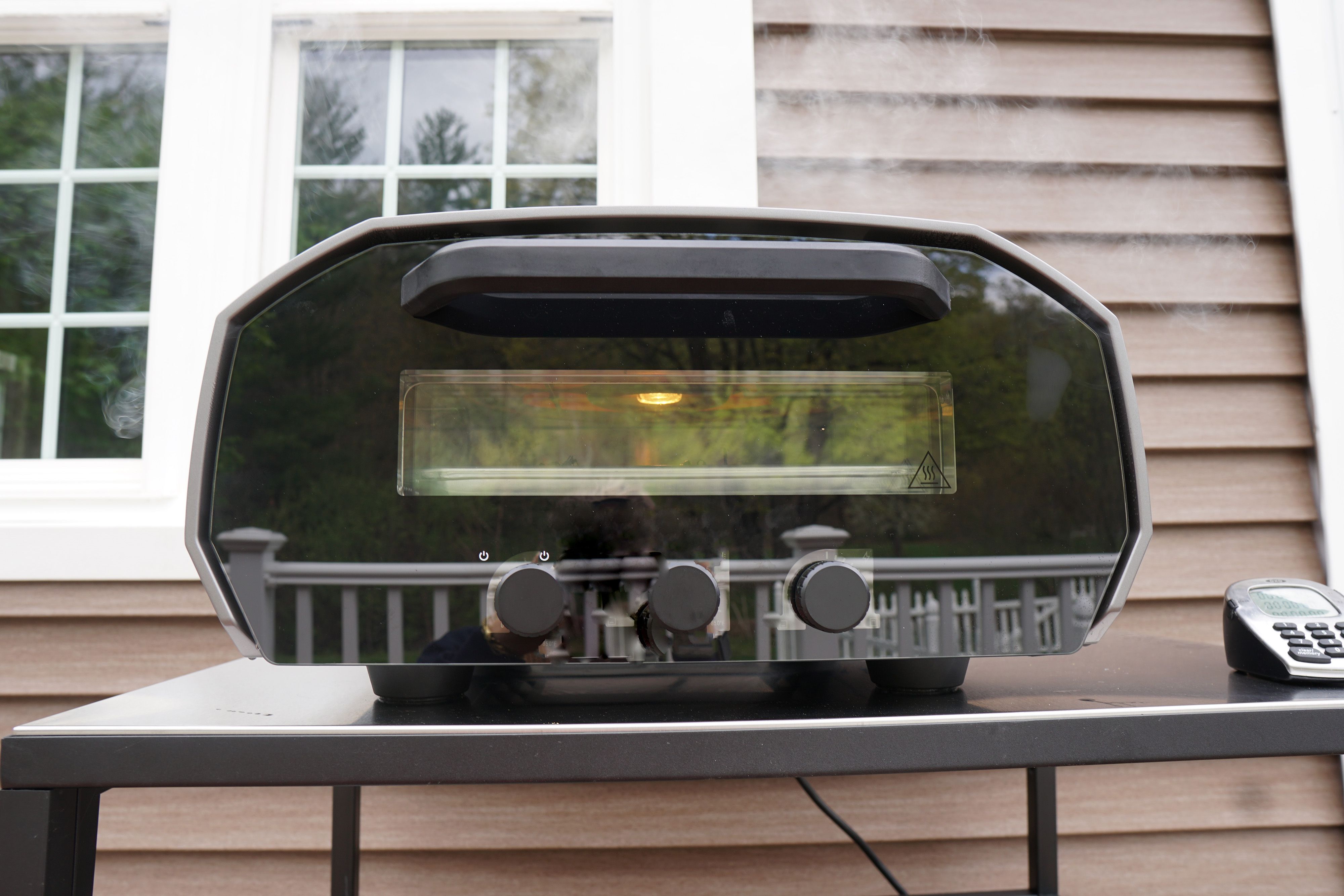 A pizza oven letting off some smoke outdoors